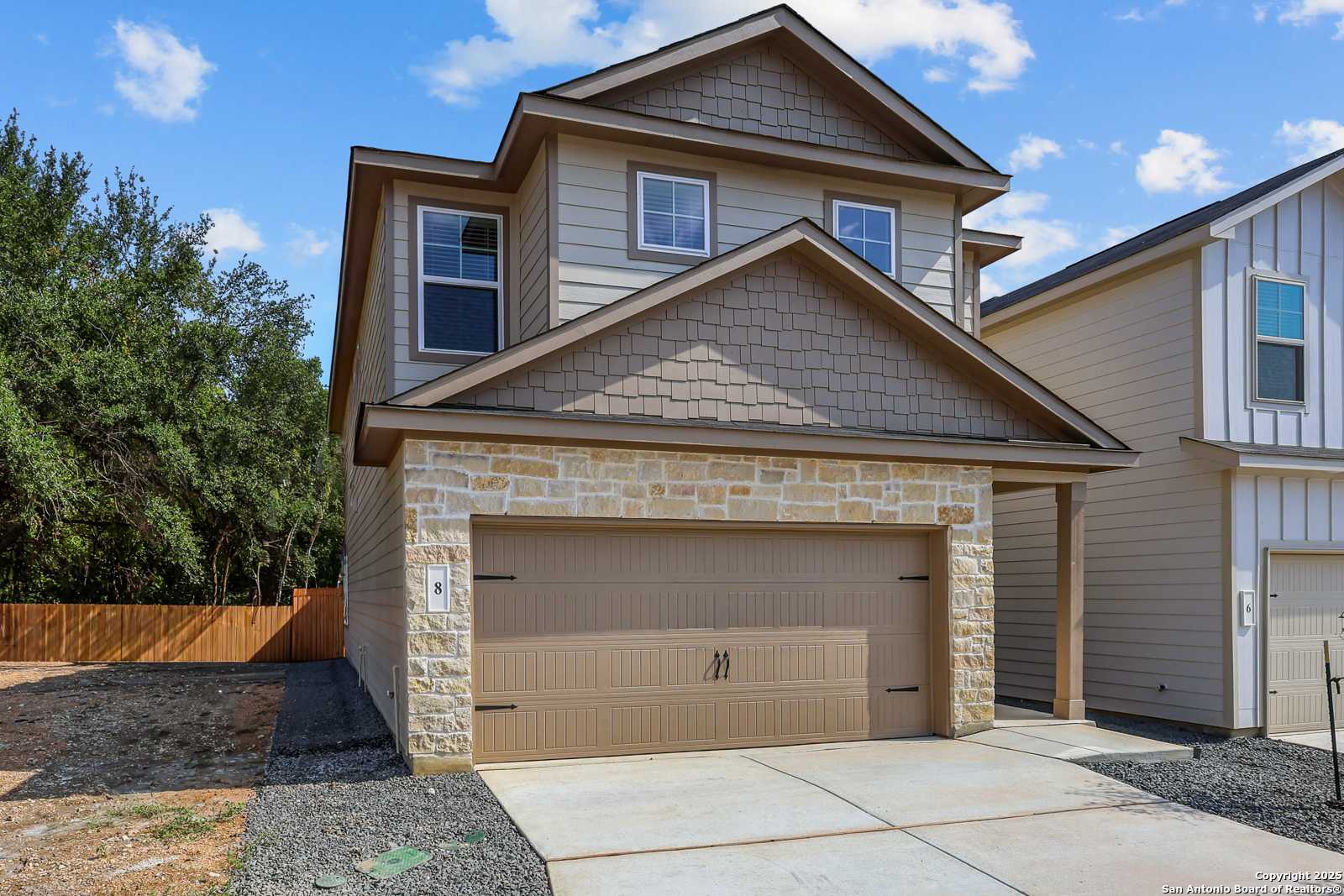 Modern two-story Charlotte B home with stone facade, beige siding, and 2-car garage in Cedar Heights, San Antonio, Texas