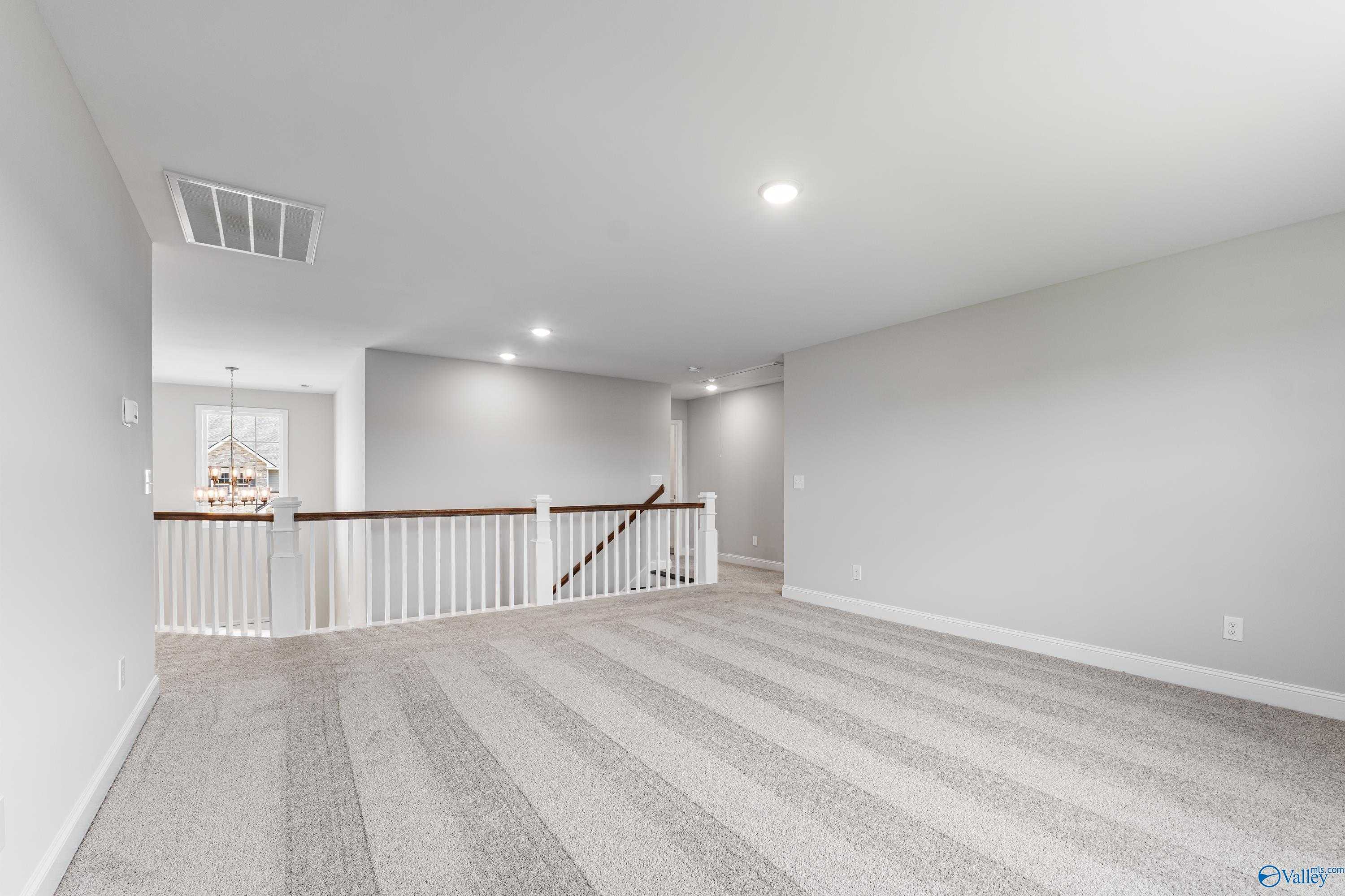 Spacious upstairs loft with white-railed balcony overlooking chandelier in The Madison A 5-bedroom home, Toney, Alabama