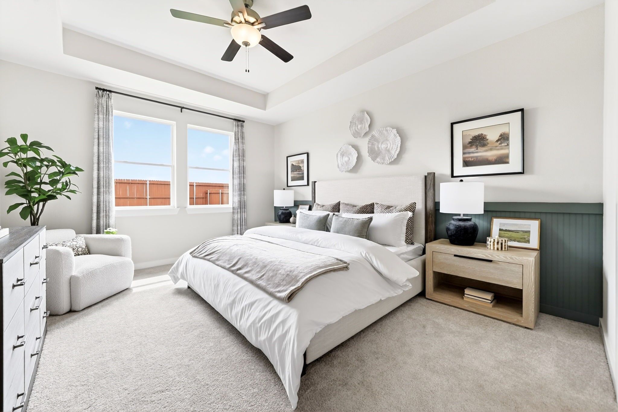 Bright master bedroom with tray ceiling and cozy seating area in The Laurel M floor plan at Parks at Foster Crossing.
