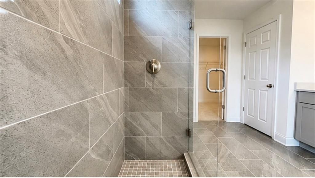 Walk-in tiled shower with glass door in The Hickory C floor plan at Wehunt Meadows, Hoschton, Georgia.