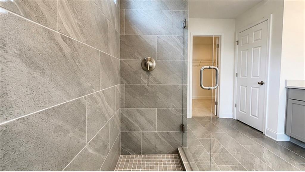 Walk-in tiled shower with glass door in The Hickory C floor plan at Wehunt Meadows, Hoschton, Georgia.