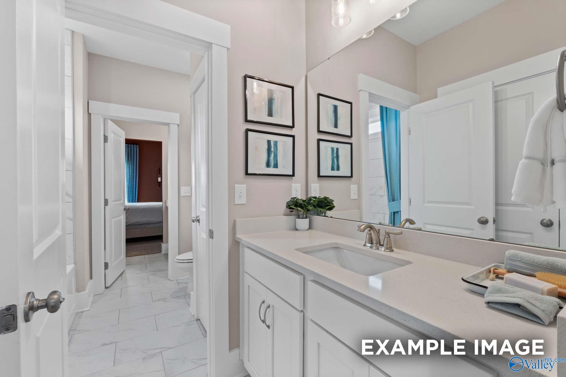 Elegant master bathroom with white shaker vanity, undermount sink, frameless mirror, and abstract art in Davidson Homes The Finleigh, Huntsville AL