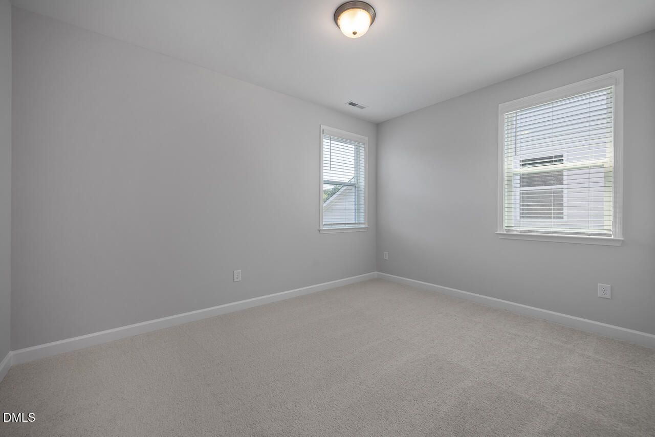 Bright, neutral-toned bedroom in The Ashport L floor plan at Sage on North Main in Wake Forest, North Carolina.