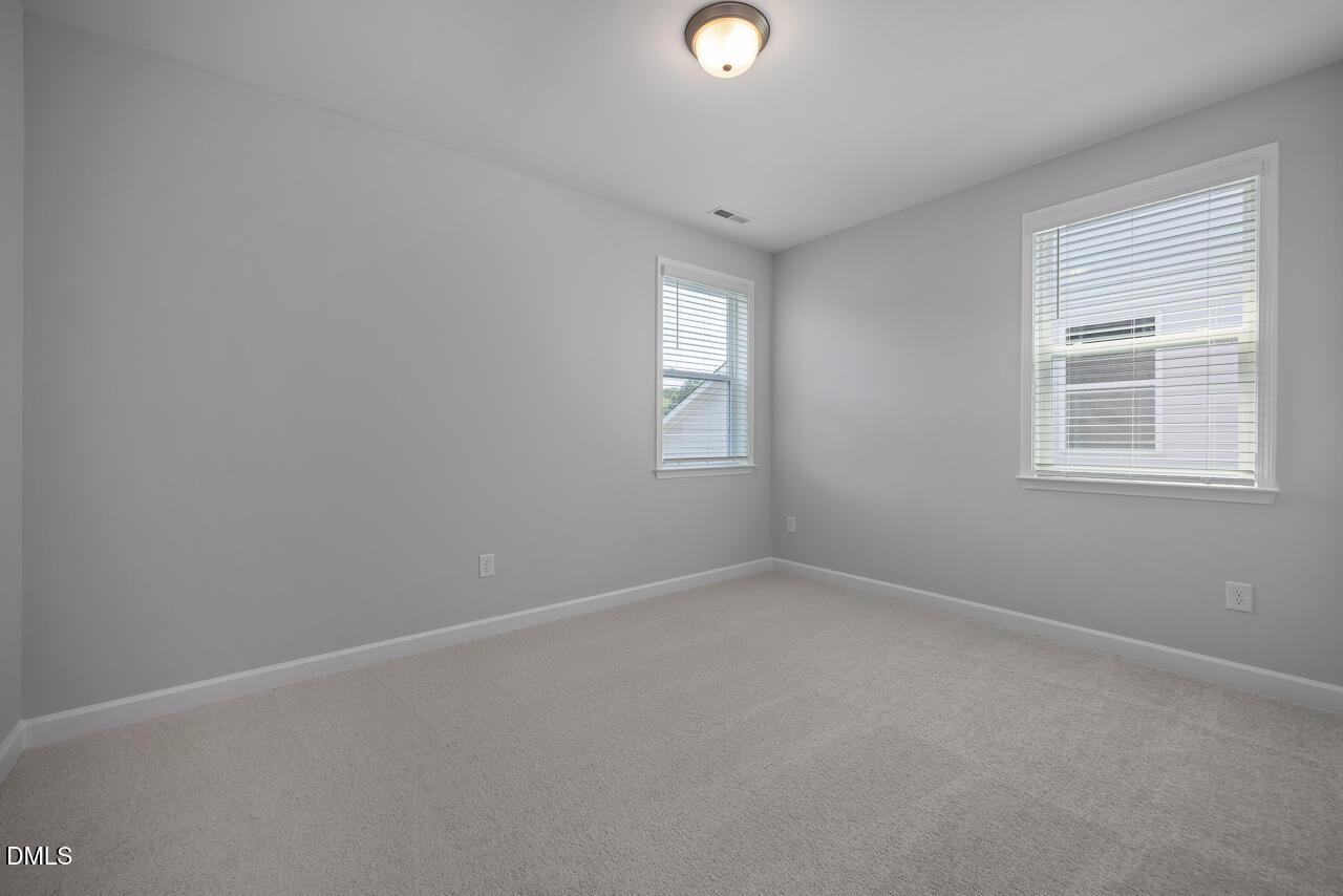 Bright, neutral-toned bedroom in The Ashport L floor plan at Sage on North Main in Wake Forest, North Carolina.