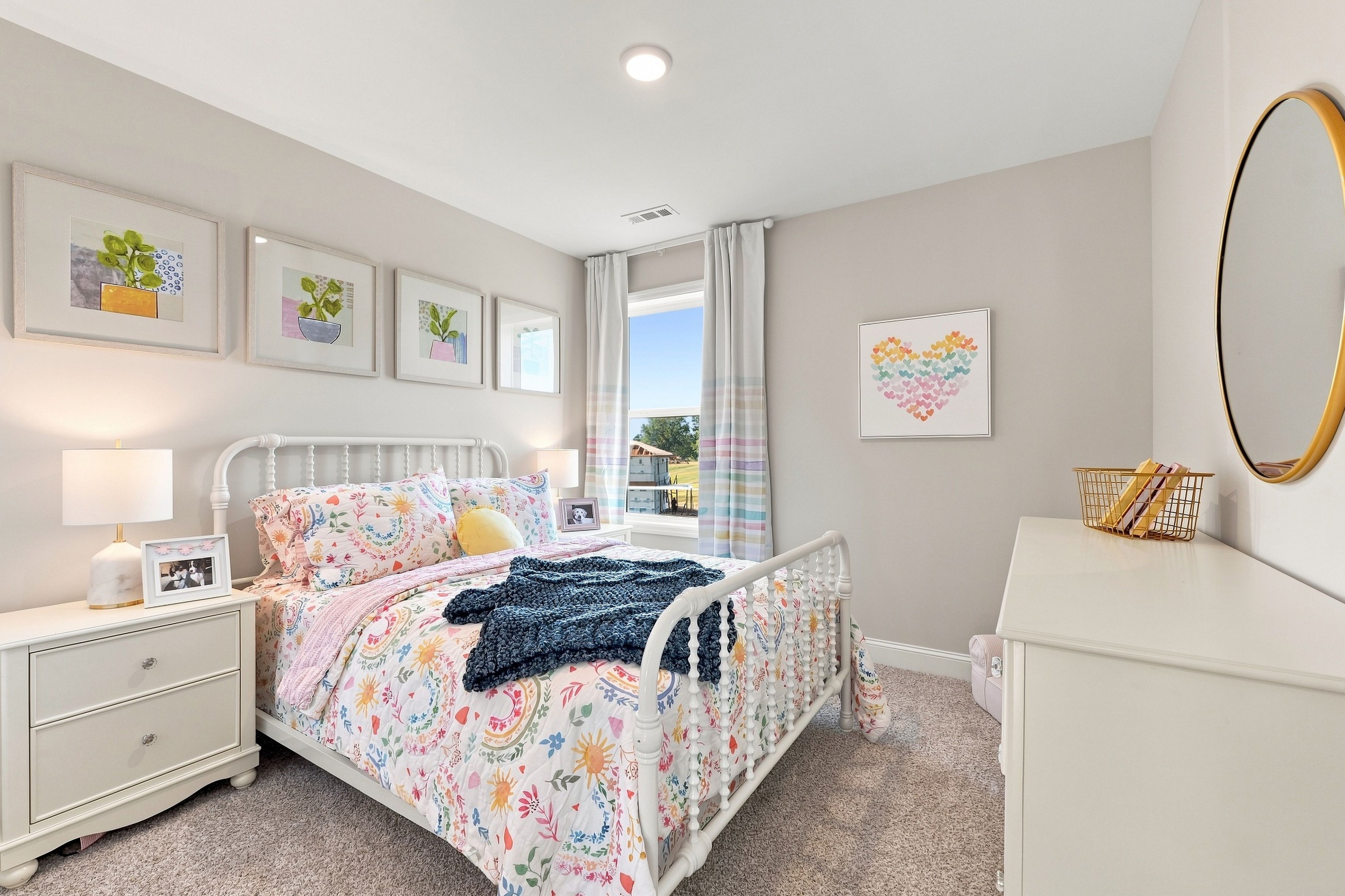 Bright bedroom with white spindle bed, floral bedding, and pastel decor at Bailey Park by Davidson Homes in Fayetteville, Tennessee