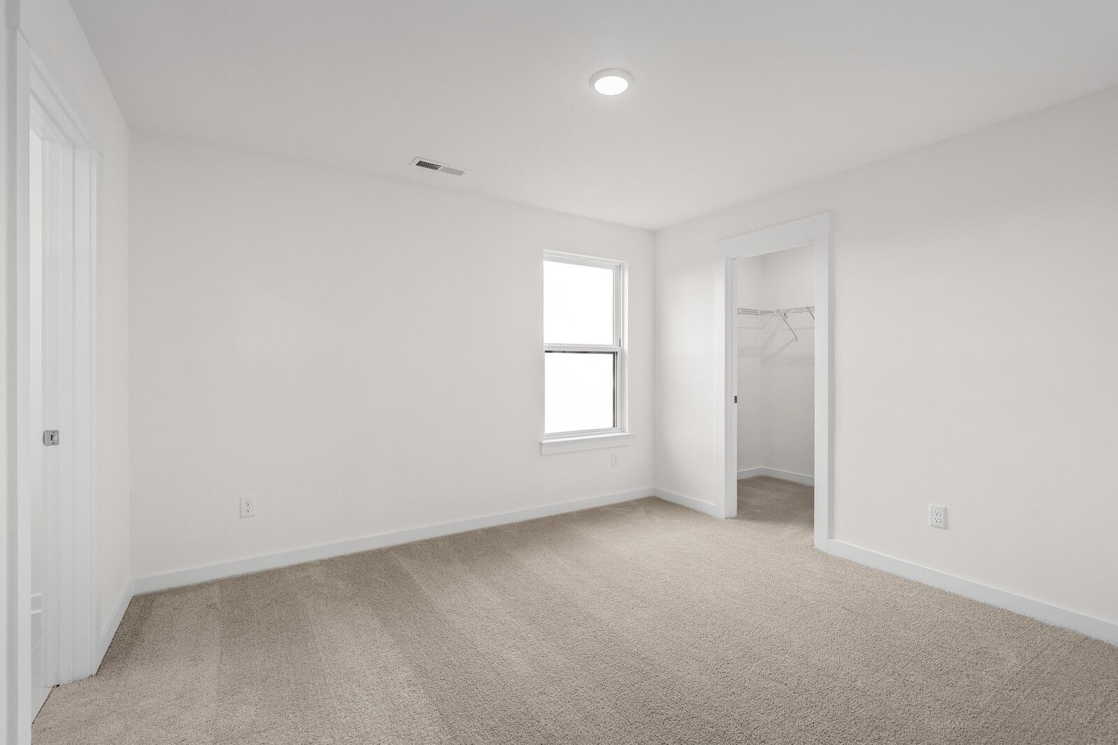 Bright, carpeted bedroom with walk-in closet in The Henry C floor plan by Davidson Homes in Mt. Juliet, Tennessee.