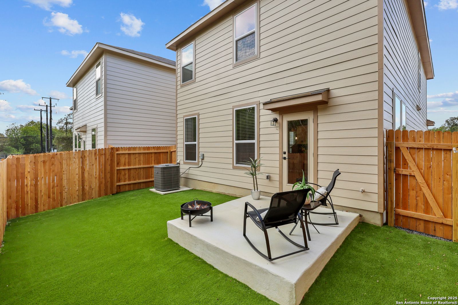 Private backyard with covered patio, fire pit, and Adirondack chairs in lush green lawn, Davidson Homes Charlotte B, Cedar Heights San Antonio