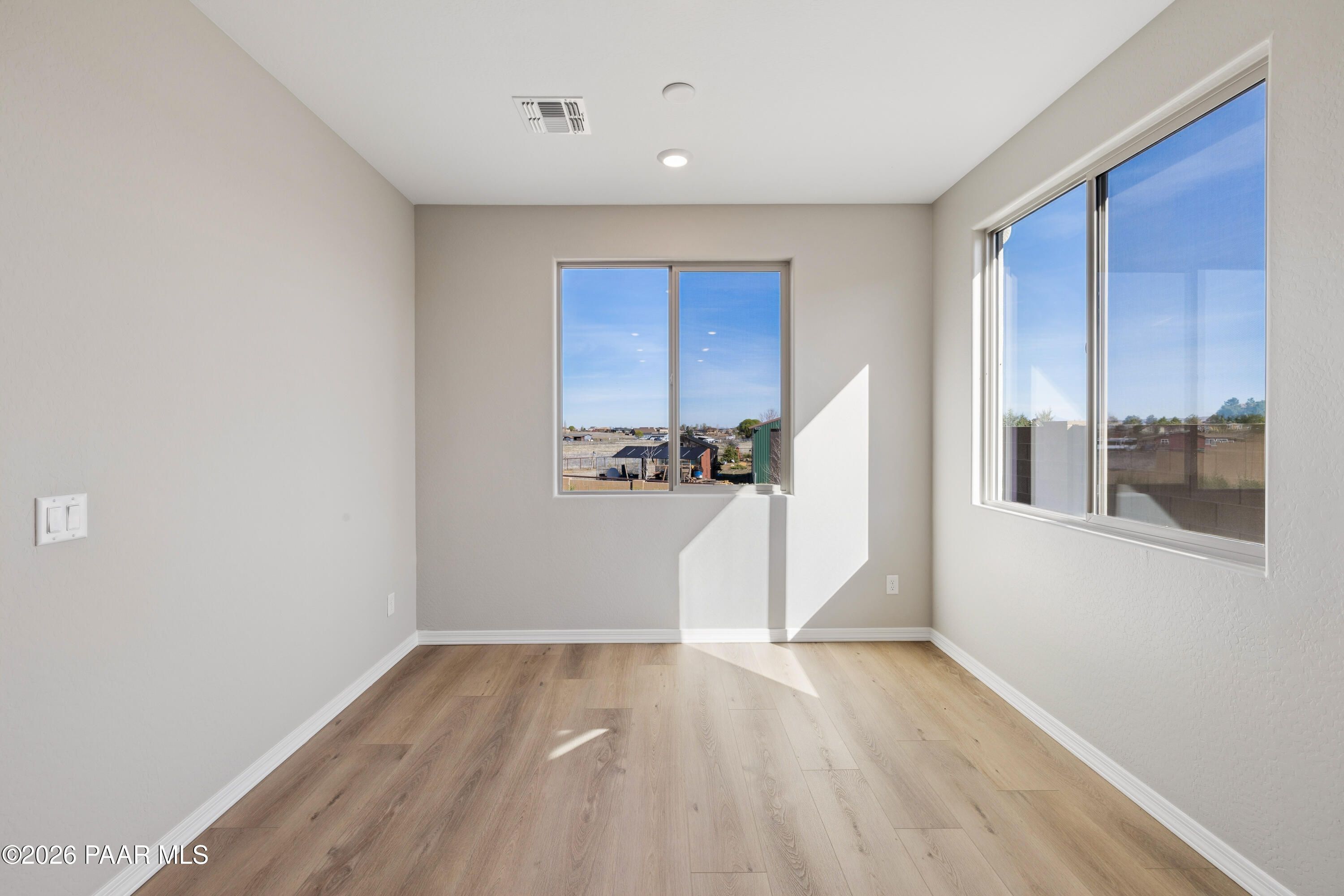 Bright bedroom with large windows showcasing Arizona desert view and hardwood floors in Davidson Homes The Harmony A, Prescott Valley