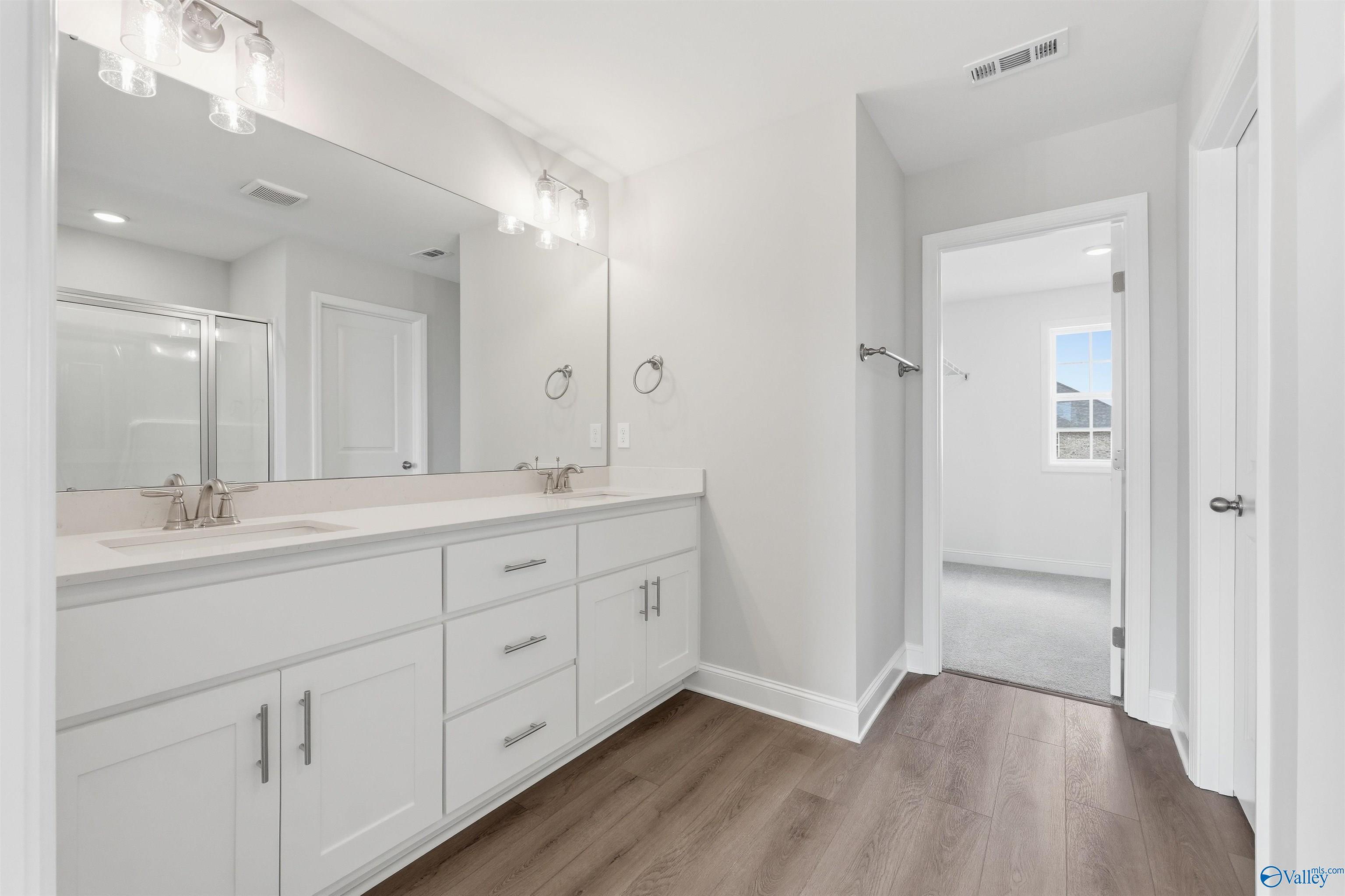 Modern dual-vanity bathroom with white cabinetry in The Shelby D floor plan at Evergreen Mill, Madison, Alabama.