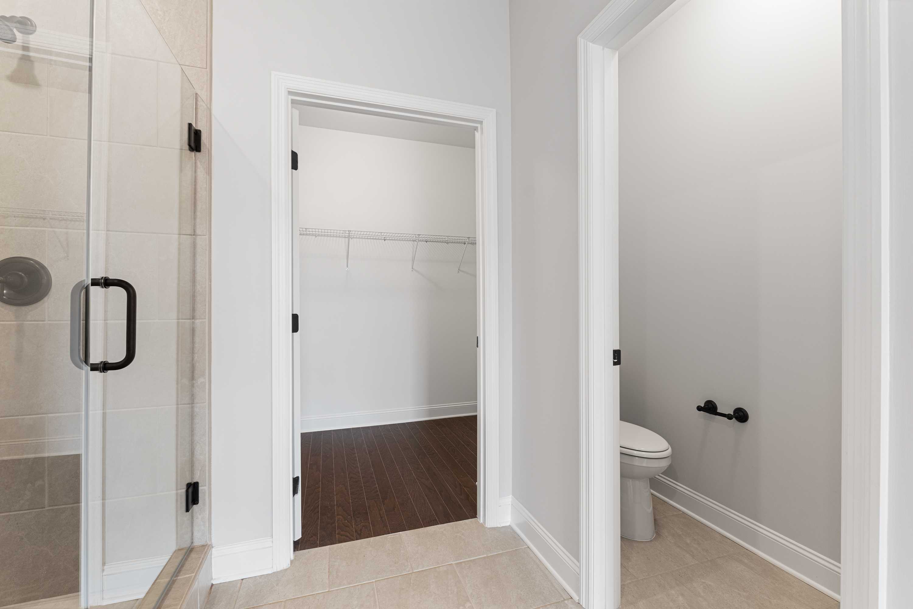 Master bathroom in The Copeland showcasing walk-in shower, spacious closet, and powder room in Davidson Homes design