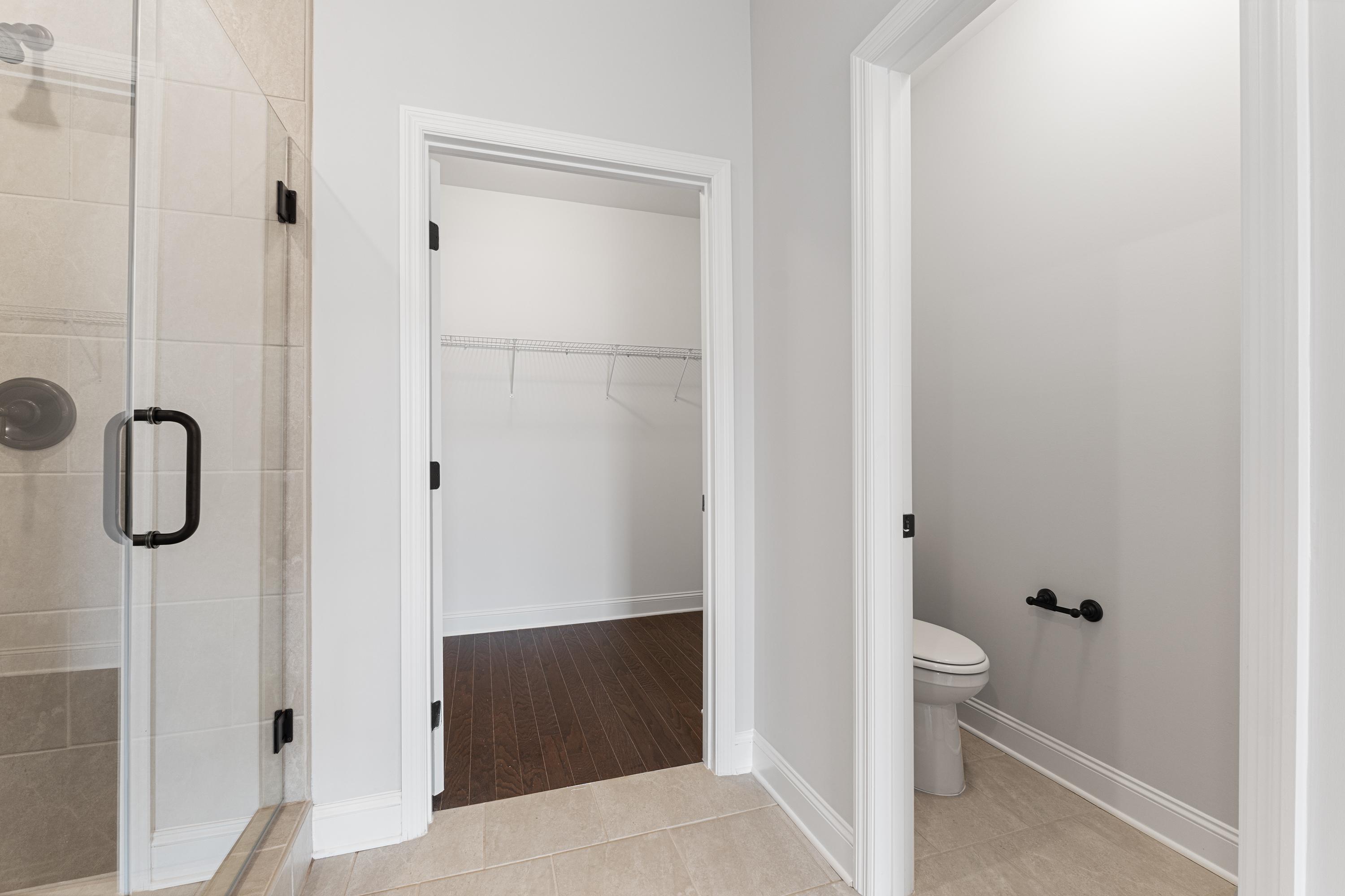 Master bathroom in The Copeland showcasing walk-in shower, spacious closet, and powder room in Davidson Homes design