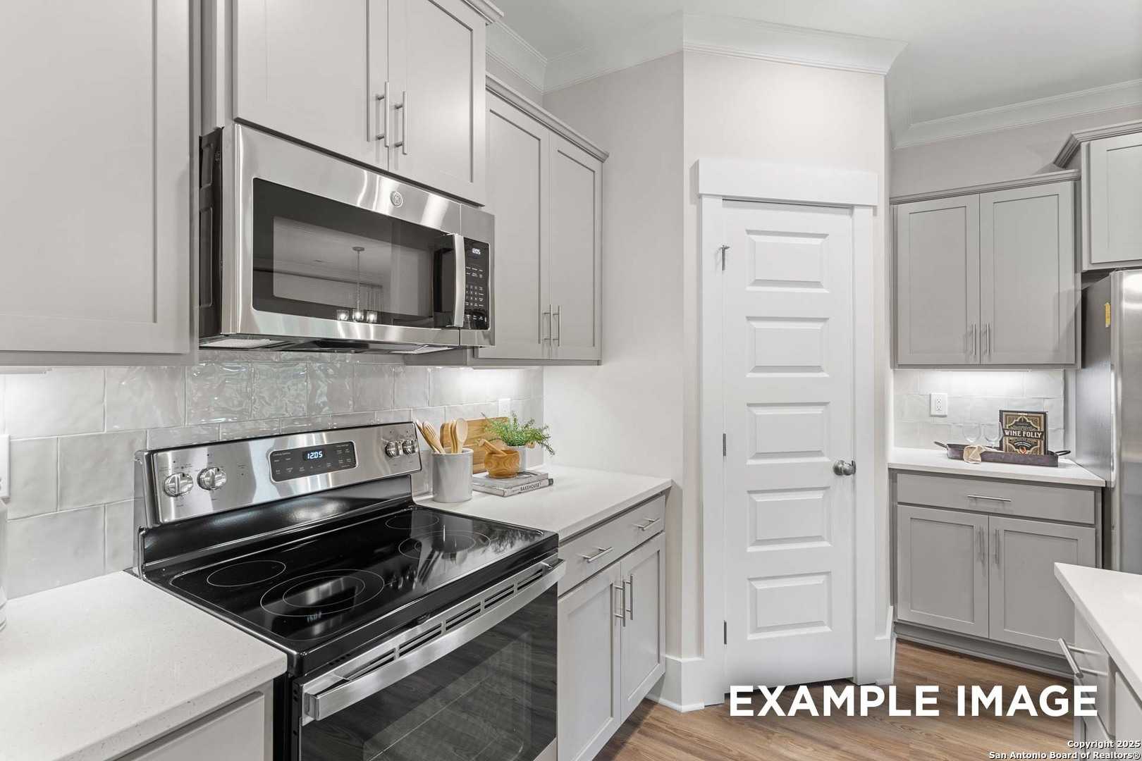 Modern white shaker kitchen with stainless steel appliances, subway tile backsplash in Davidson Homes The Daphne H, Seguin TX