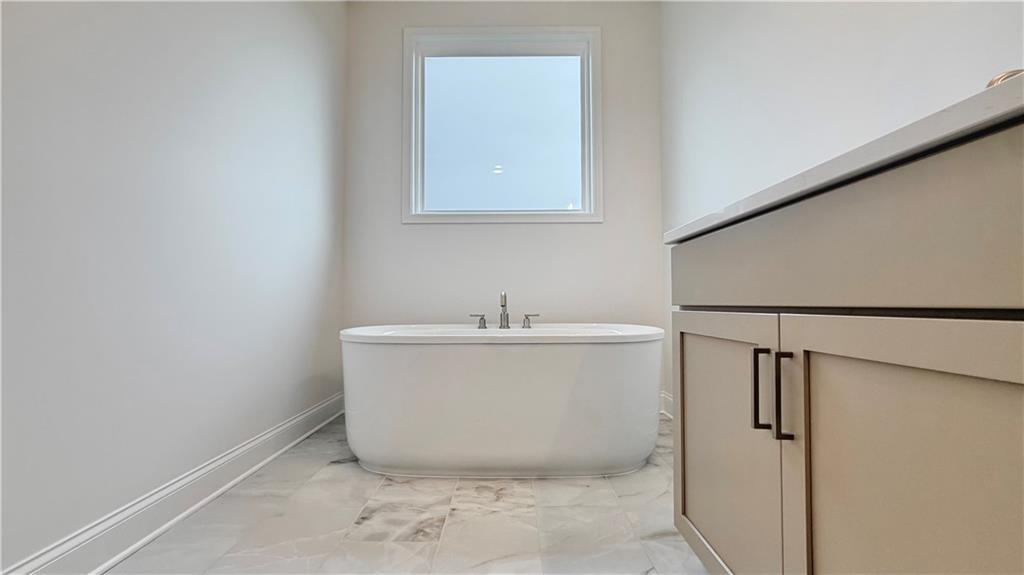 Modern freestanding soaking tub in master bathroom of The Glenwood A floor plan at Wehunt Meadows in Hoschton, Georgia.