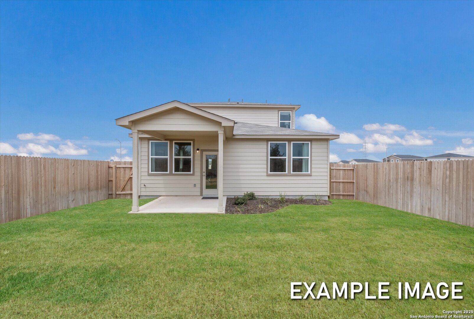 Two-story beige home with covered porch, windows, and fenced grassy yard under blue sky in Agave, San Antonio, Texas