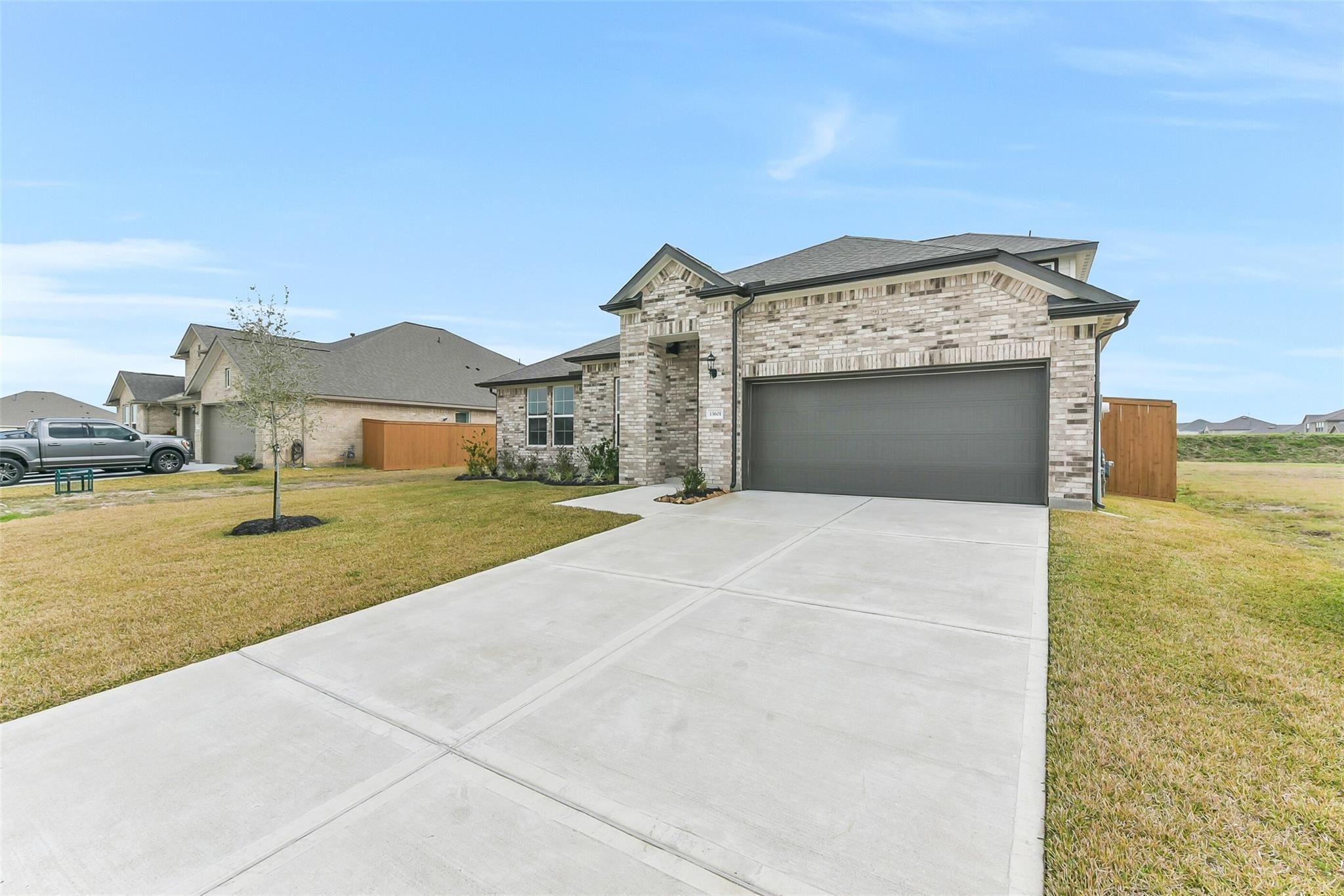 Modern brick single-story home with 2-car garage and concrete driveway in Lago Mar, Texas City, Texas by Davidson Homes