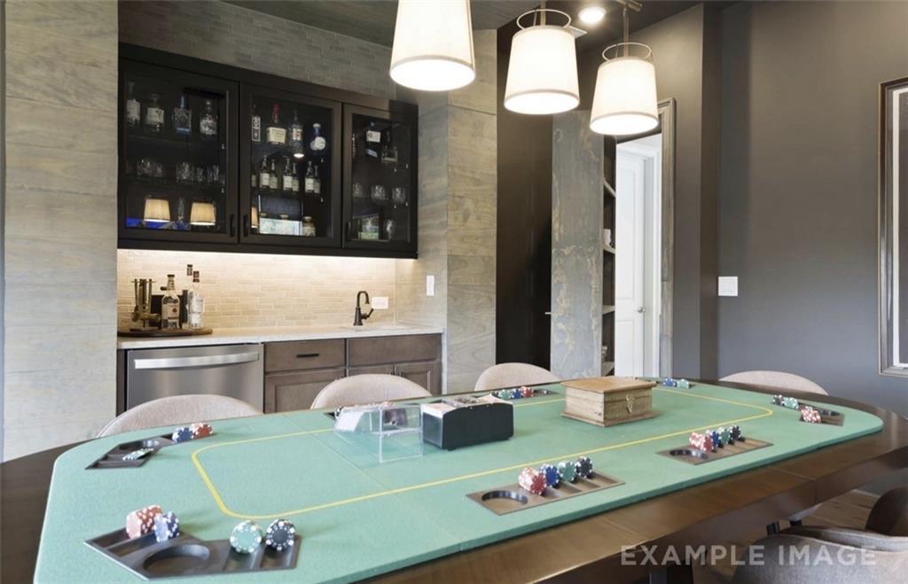 Elegant game room with green felt poker table, chip stacks, and built-in liquor bar in Davidson Homes The Seaside A, Woodstock, GA