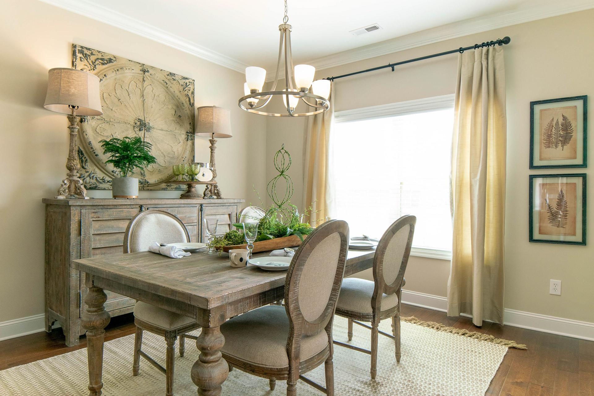 Elegant dining room at The Dairy at Oak Grove in South Huntsville AL with rustic wooden table, chandelier, and sheer curtains