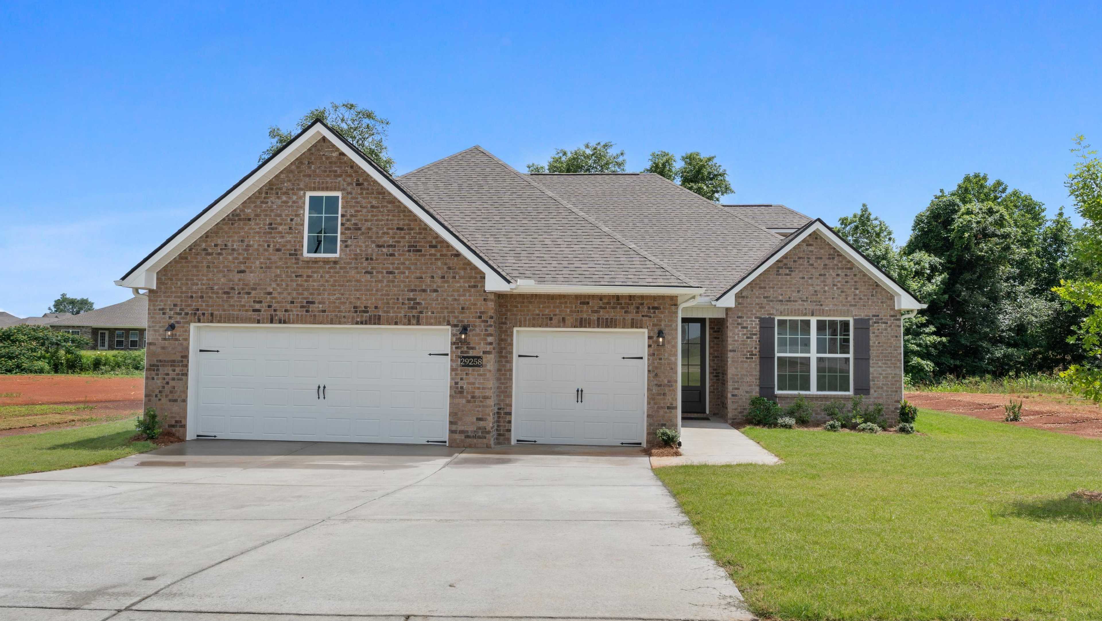 New brick home with two-car garage and landscaped yard at Davidson Homes open house, 29258 Crawfish Drive
