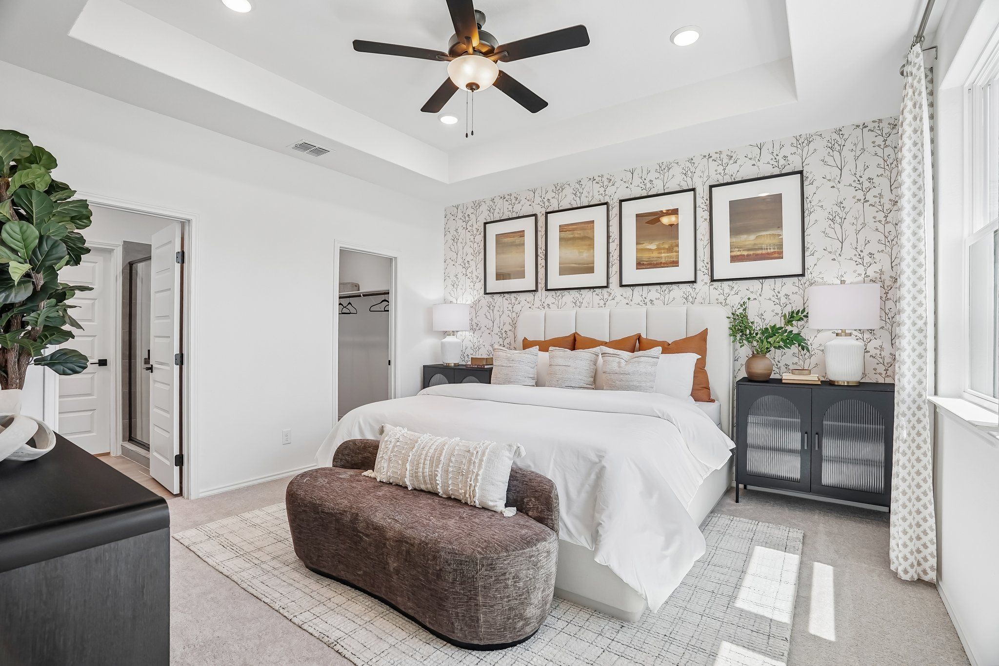 Spacious primary bedroom at Fairway Crossing in Converse, TX by Davidson Homes with tray ceiling and patterned accent wall.