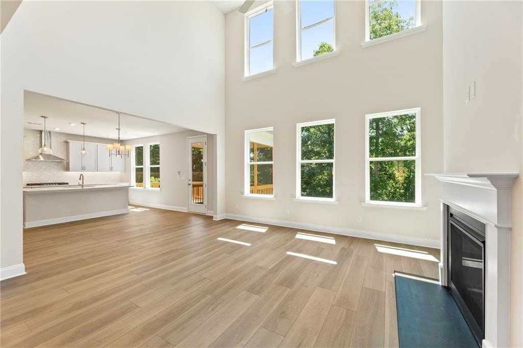 Bright open great room with gas fireplace, hardwood floors, and large windows in Davidson Homes The Hampton C, Buford, GA