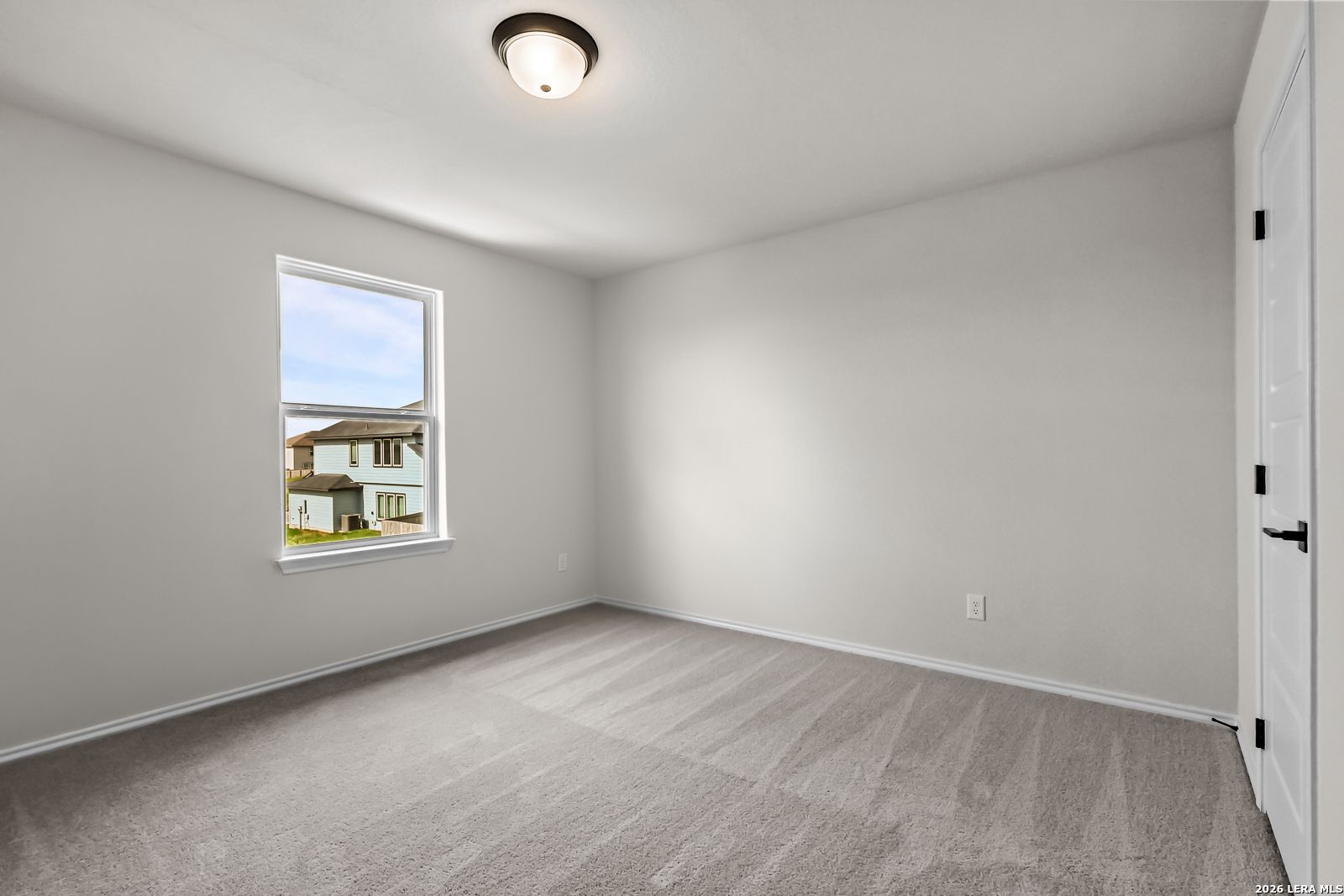 Bright bedroom with neutral walls and plush carpet in The Douglas C floor plan at Hannah Heights, Seguin, Texas.