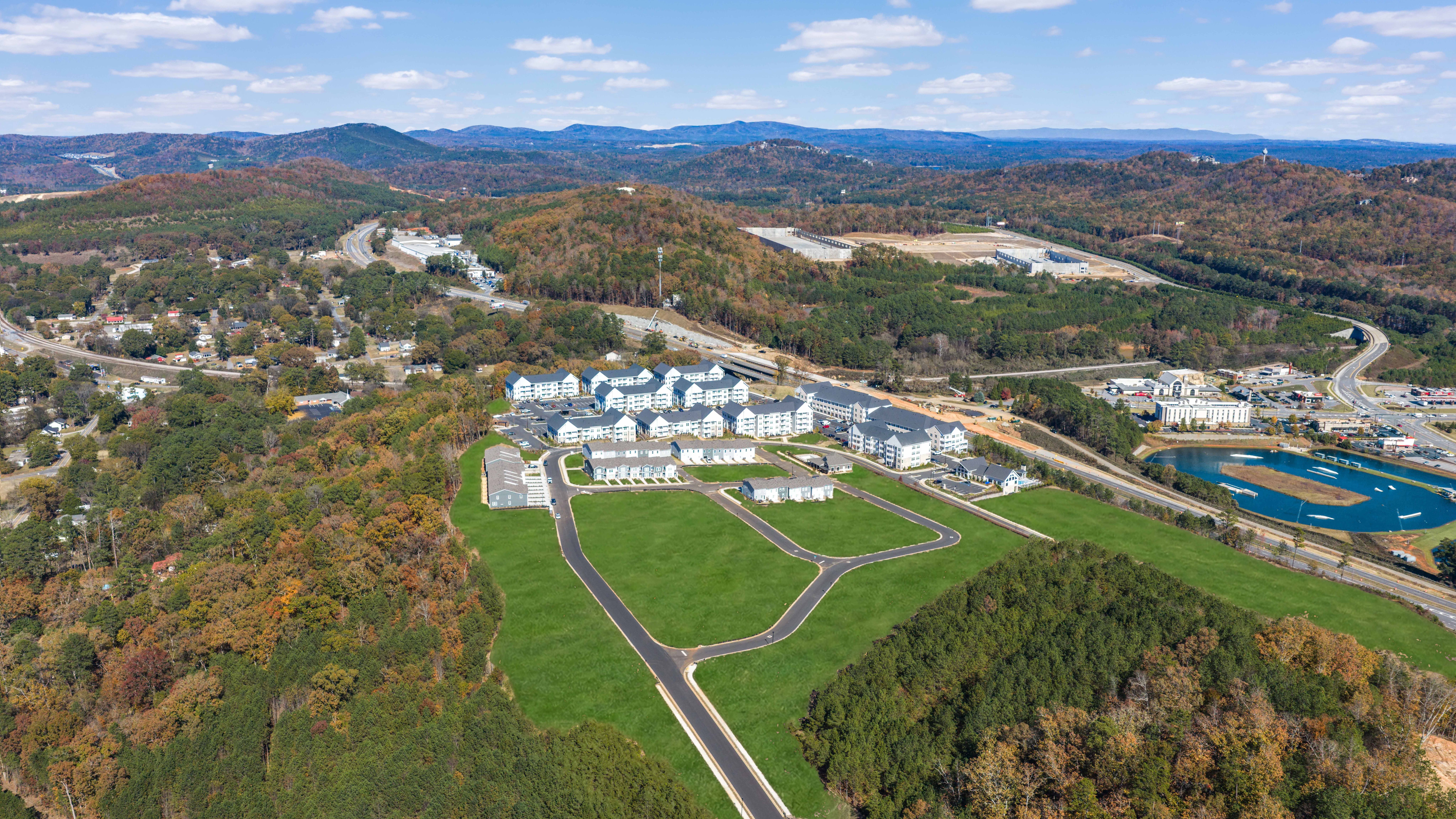 Aerial view of Stegall Village in Emerson Georgia showcasing white townhomes, green lawns, autumn woodlands, and distant mountains