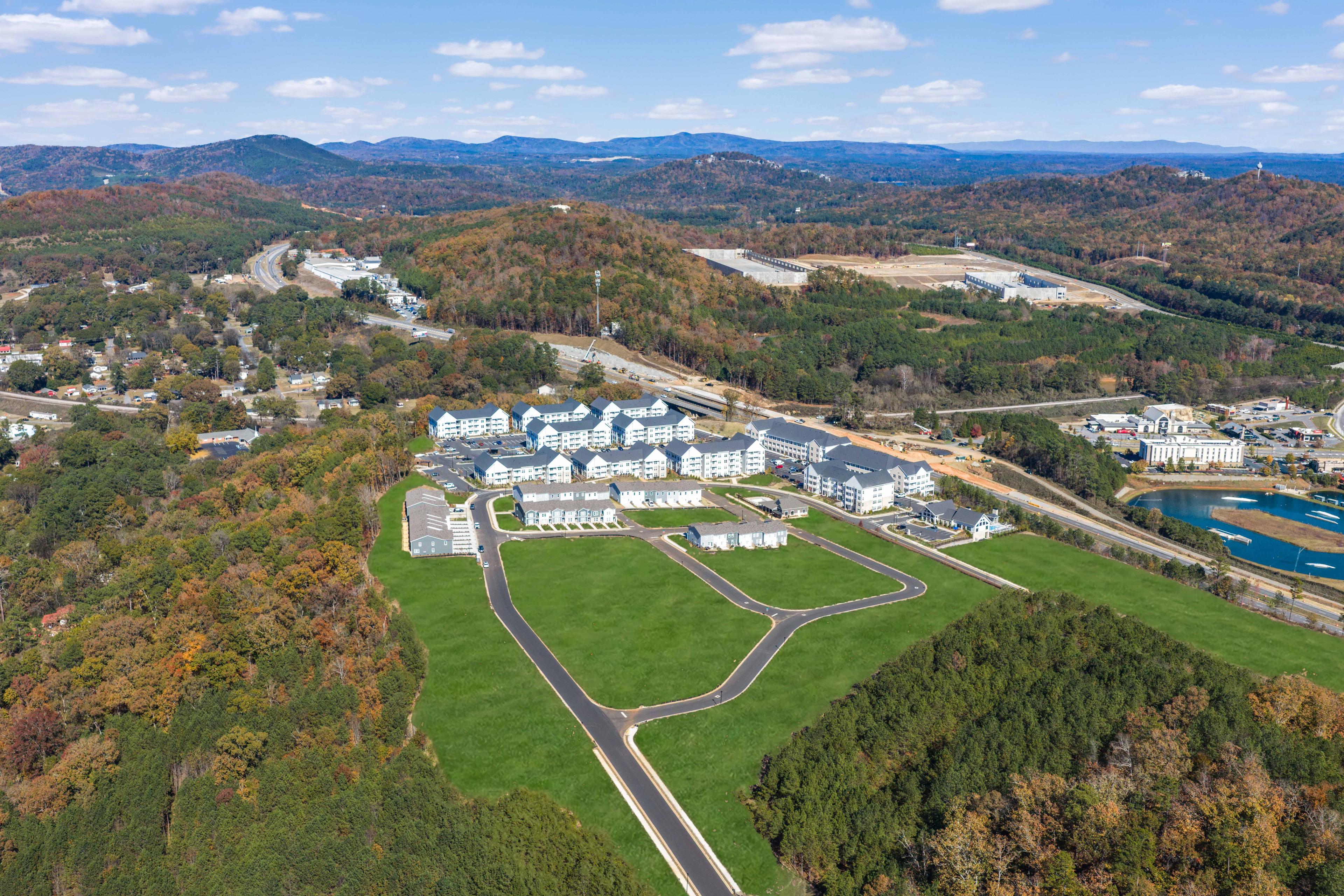 Aerial view of Stegall Village in Emerson Georgia showcasing white townhomes, green lawns, autumn woodlands, and distant mountains