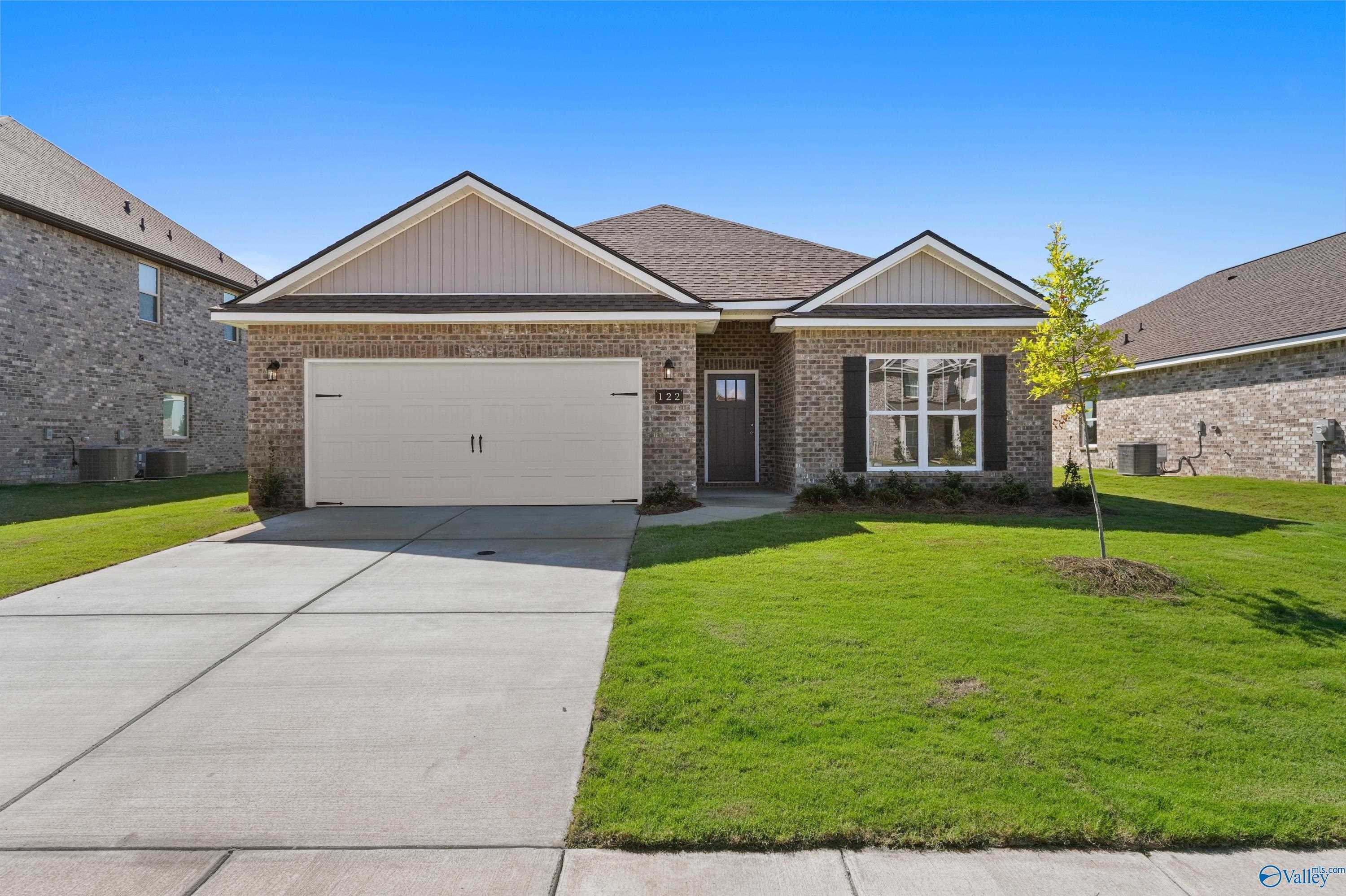 Modern brick 1-story home with 2-car garage, driveway, and lush front lawn in Clearview, Hazel Green, Alabama by Davidson Homes The Everett