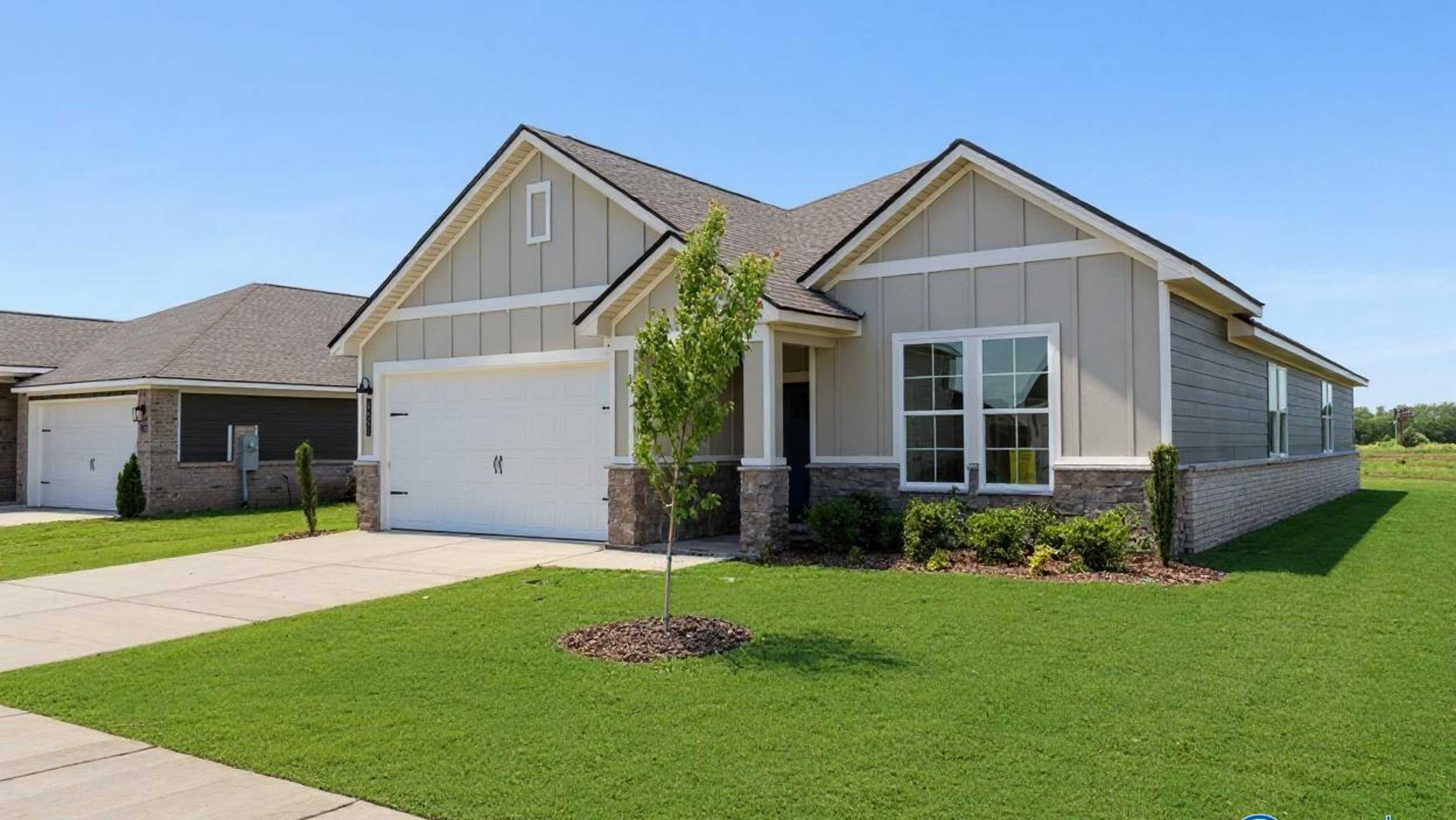 Modern beige Craftsman home with attached garage, front porch, and landscaped yard at Davidson Homes open house on Buck Road