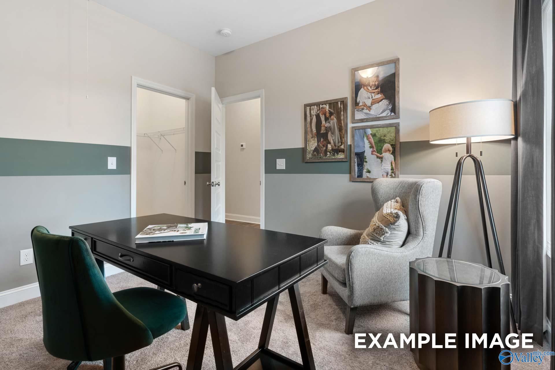 Stylish home office with black desk, green velvet chair, and cozy sitting area in Davidson Homes Camilla C, Hartselle, Alabama