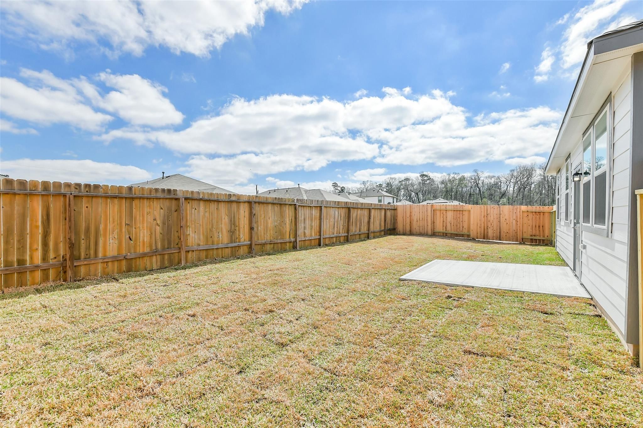 Private fenced backyard with lush grass and covered patio in Davidson Homes The Colorado F, Liberty Estates, Cleveland, Texas