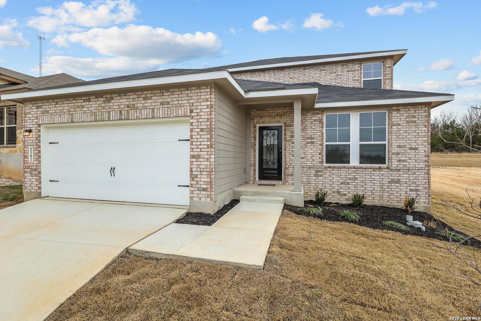 Modern 2-story brick home with 2-car garage, front porch, and driveway in Royal Crest, San Antonio, Texas - Davidson Homes Douglas E