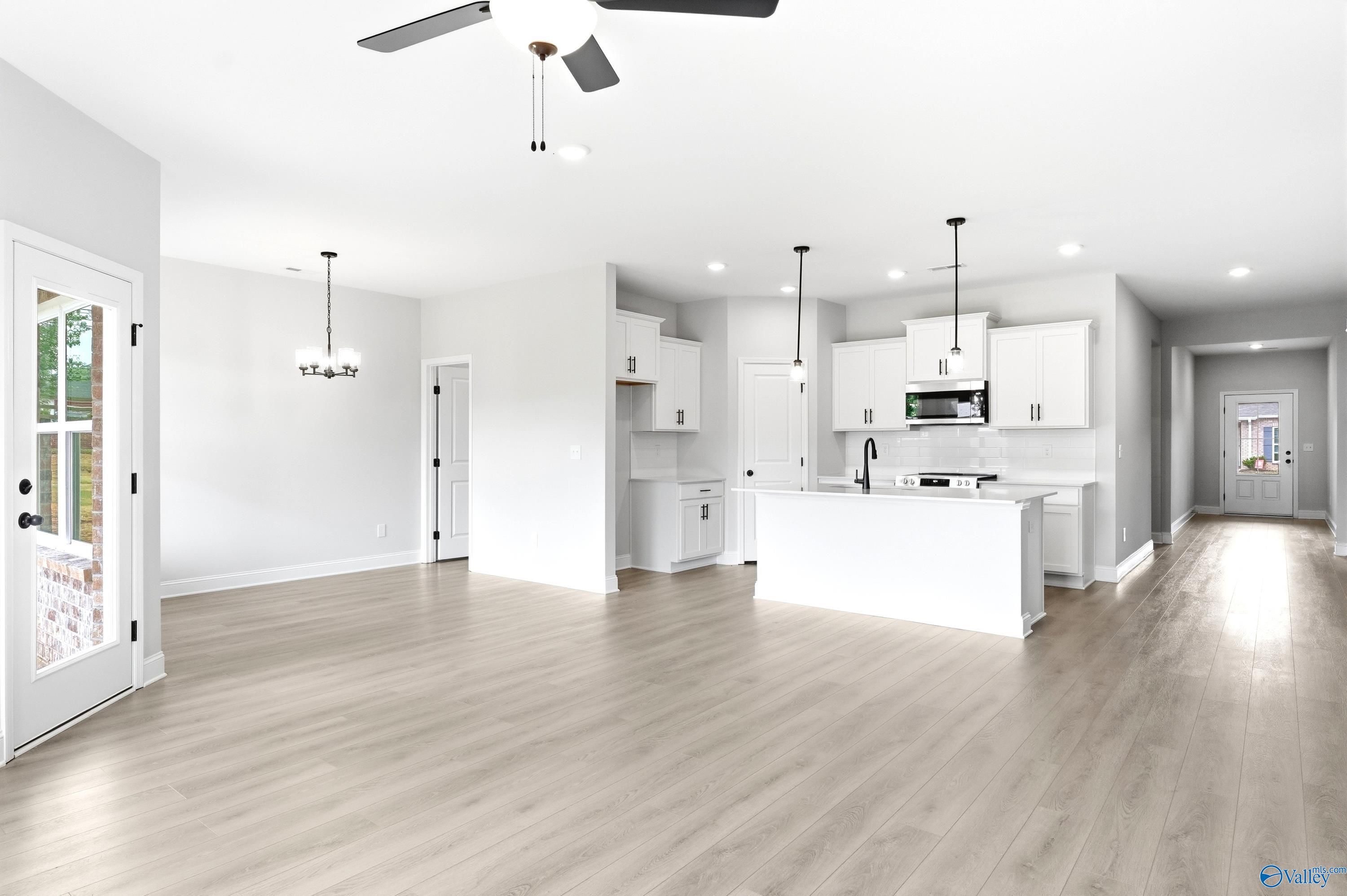 Open-concept kitchen and living area with white cabinets in The Daphne C floor plan at Flint Meadows, New Market, Alabama.