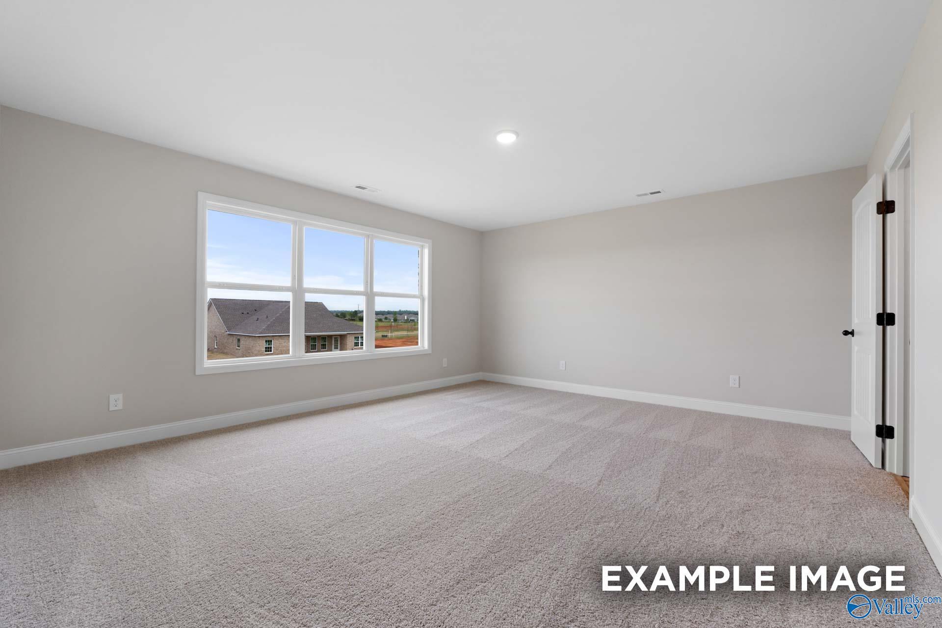 Spacious, carpeted bedroom with large windows in The Shelby B floor plan by Davidson Homes in Jaguar Hills, Huntsville, AL.