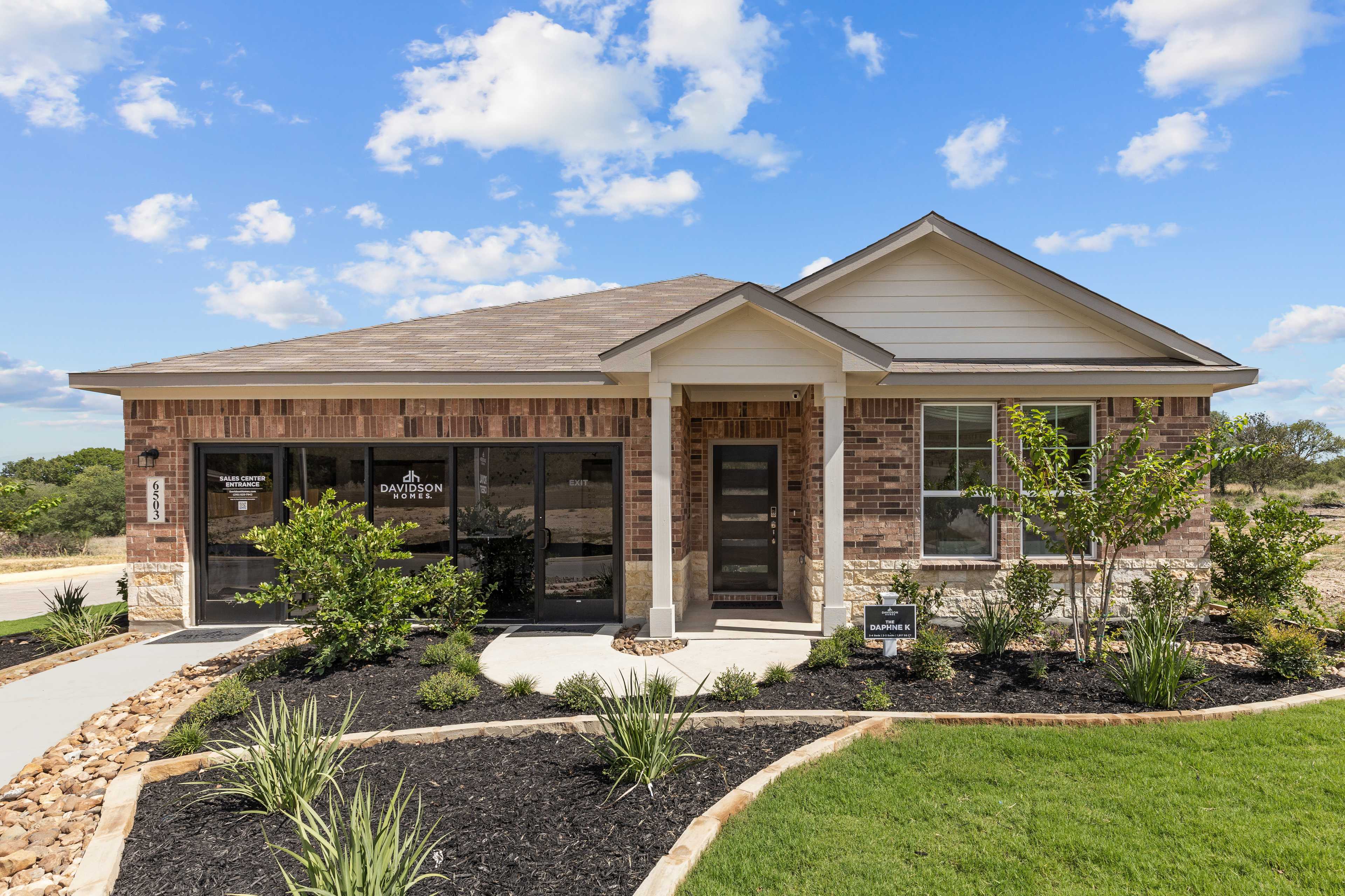 Modern brick ranch home exterior with covered porch and landscaped yard at Royal Crest in San Antonio Texas by Davidson Homes
