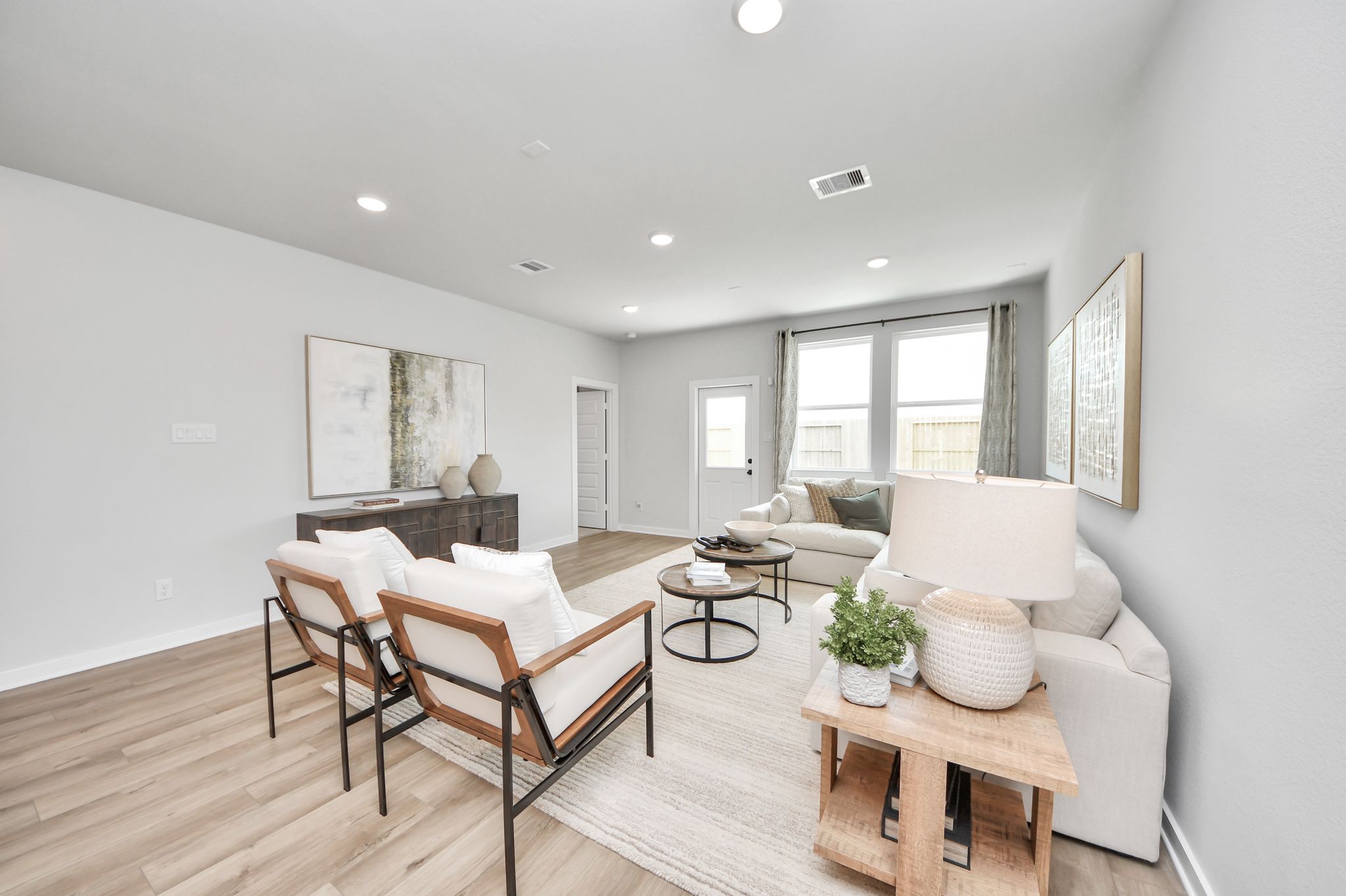 Bright, modern living room at Robins Landing in Houston, Texas with neutral decor, wood-look flooring, and natural light.