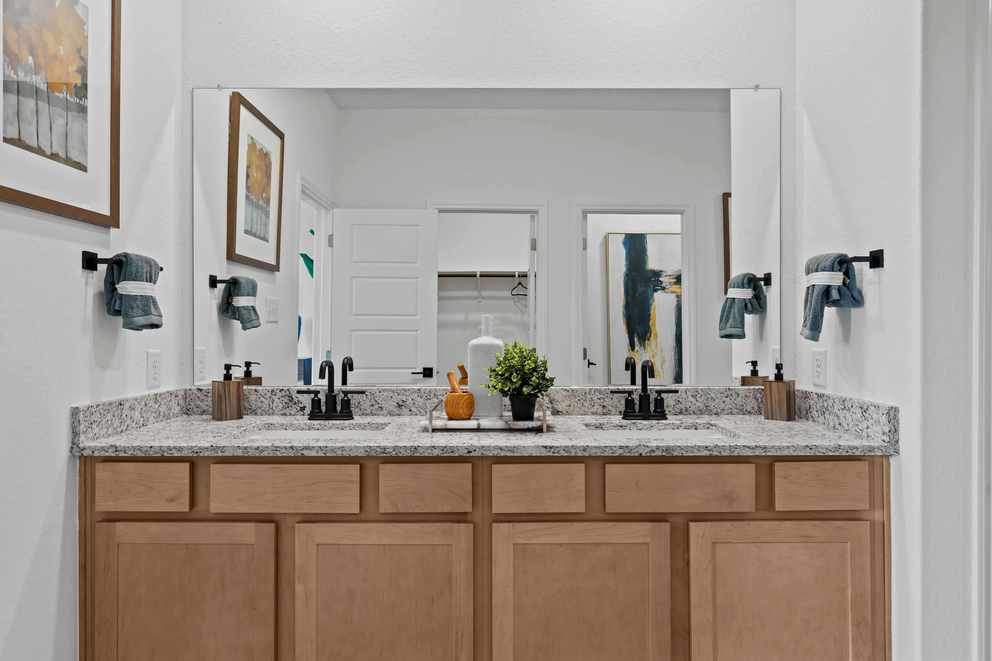 Spacious double vanity in The Douglas C master bathroom with quartz counters, shaker cabinets, dual sinks, and wall art
