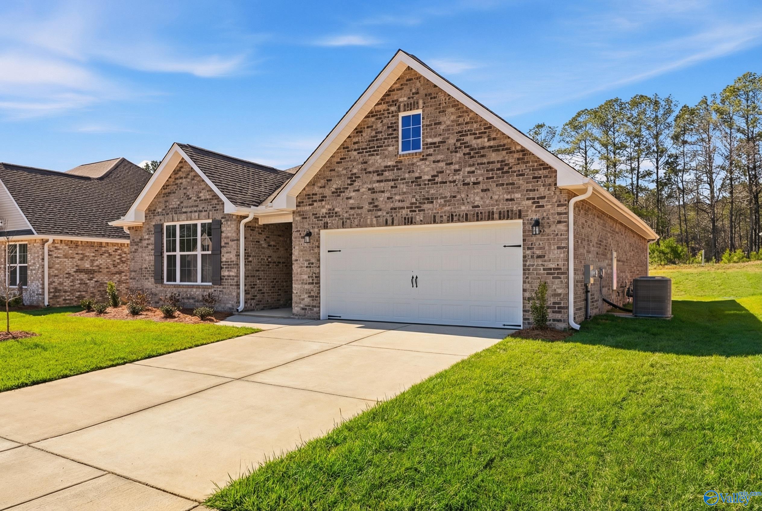 Single-story brick home with 2-car garage, concrete driveway, and lush lawn in Cain Park, Hartselle, Alabama by Davidson Homes