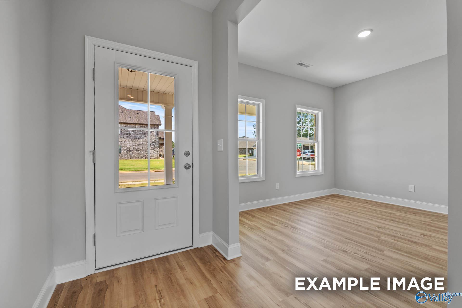 Bright interior with gray walls, hardwood floors, glass door to green lawn in 4-bedroom Shelby B home, Davidson Homes, New Market, AL