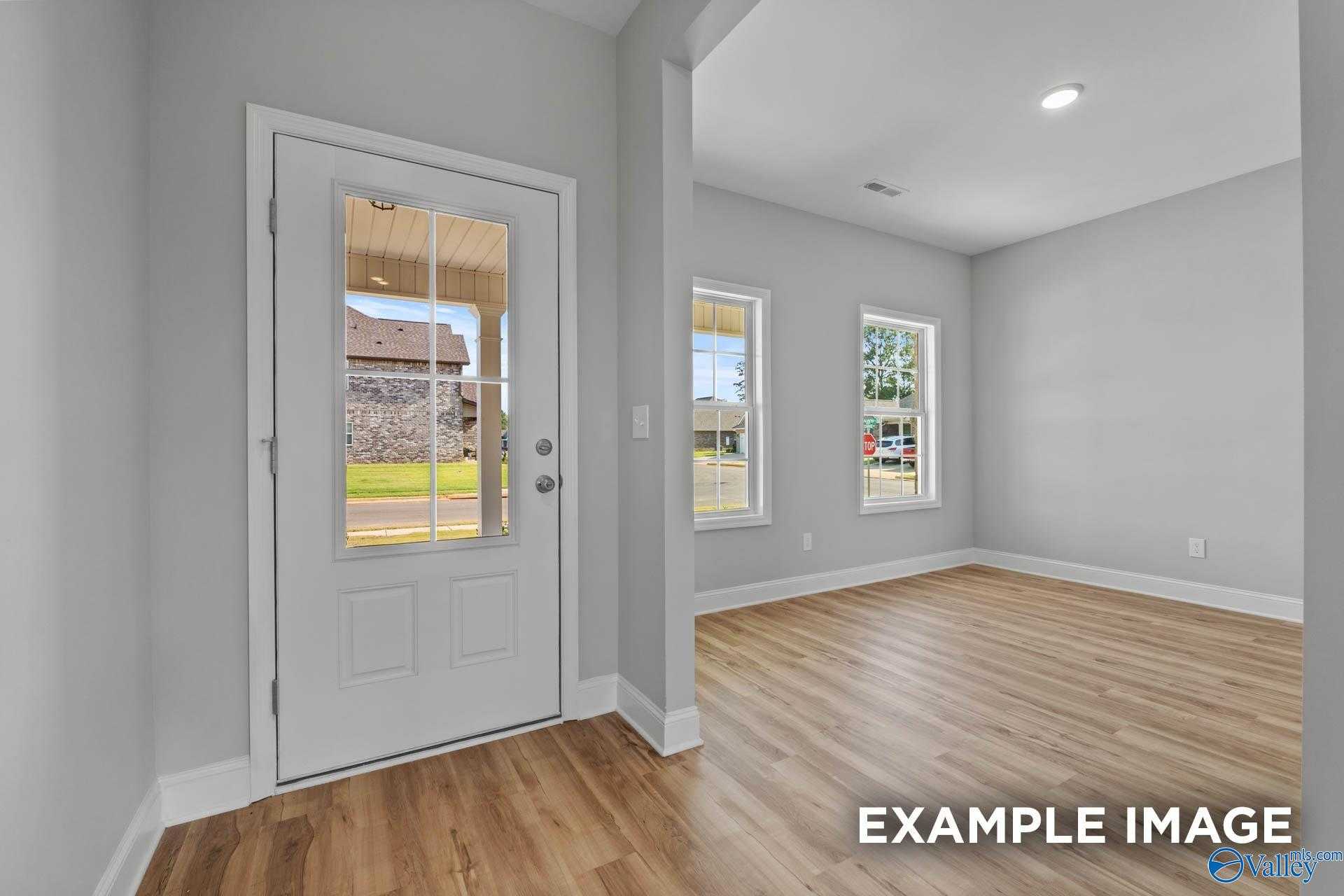 Bright interior with gray walls, hardwood floors, glass door to green lawn in 4-bedroom Shelby B home, Davidson Homes, New Market, AL