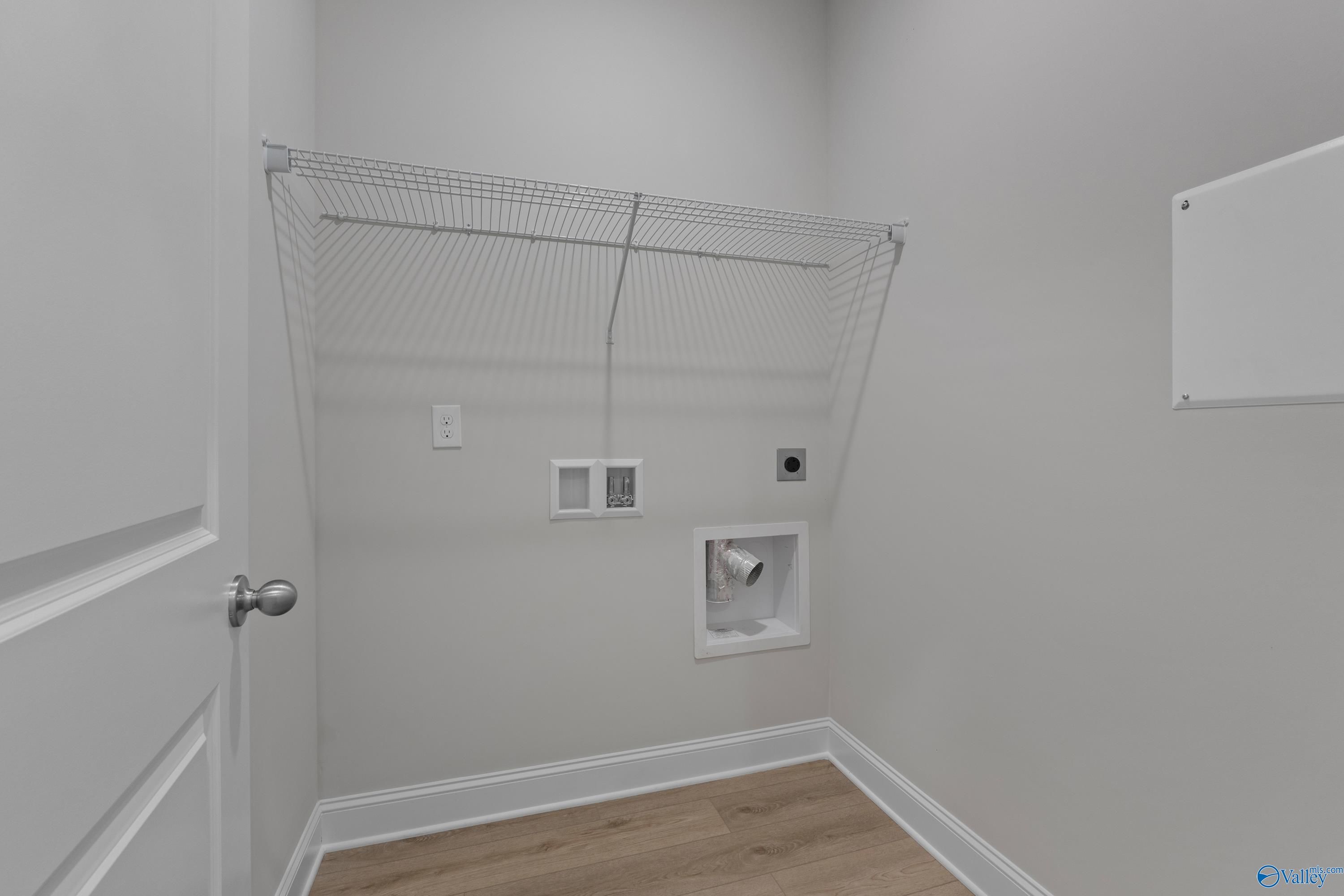 Functional laundry room with wire shelving, utility sink, and washer/dryer hookups in The Asheville plan by Davidson Homes, Huntsville AL