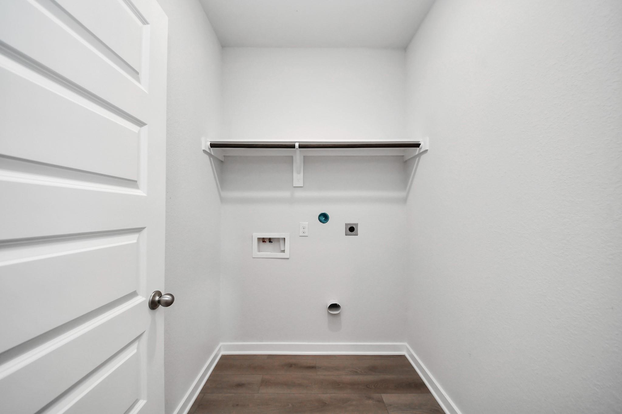 Dedicated laundry room with shelving and hookups in The Brazos F floor plan at Liberty Estates, Cleveland, Texas.