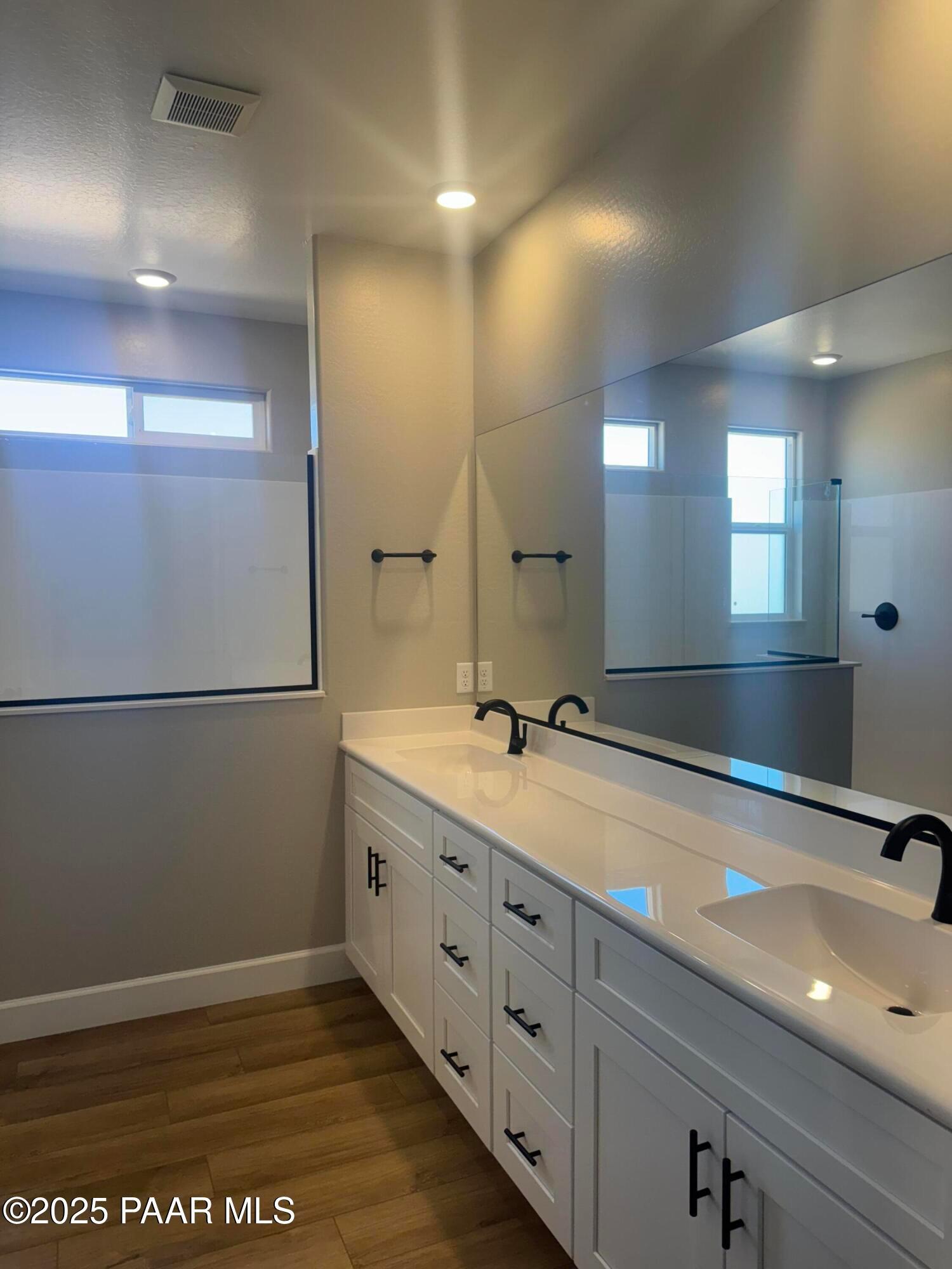 Modern master bathroom double vanity with white shaker cabinets, black faucets, and frameless mirror in Evermore Homes The Summit B, Prescott Valley, AZ