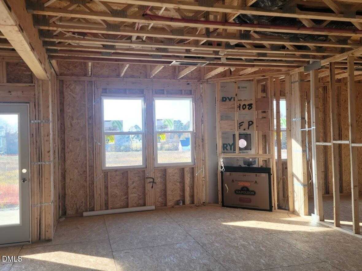 Framed living area with large windows and plywood floors in The Willow G home construction, Tobacco Road, Angier, NC