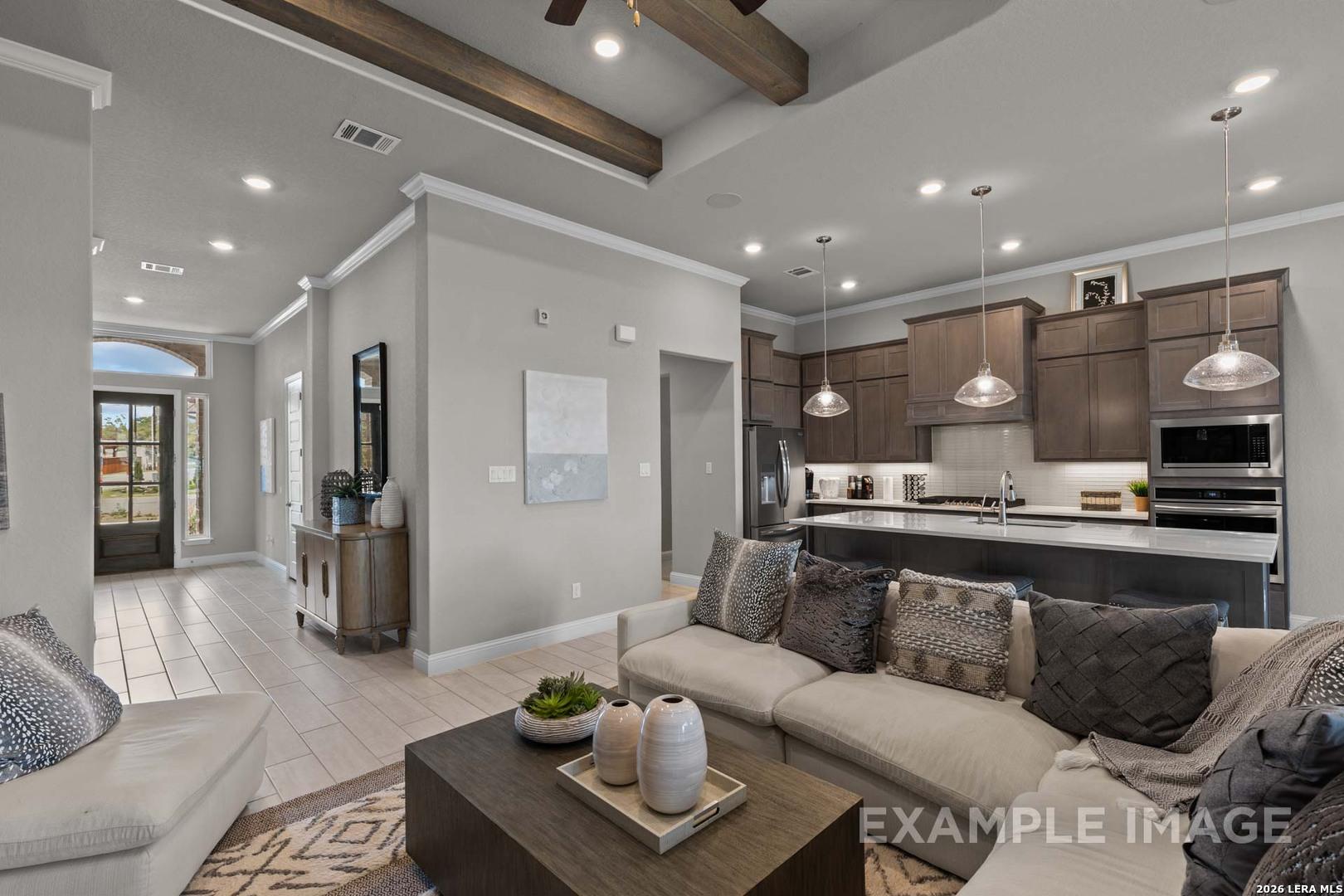 Open-concept living room and modern kitchen in The Garner C plan at The Reserve at Potranco Oaks, Castroville, Texas.