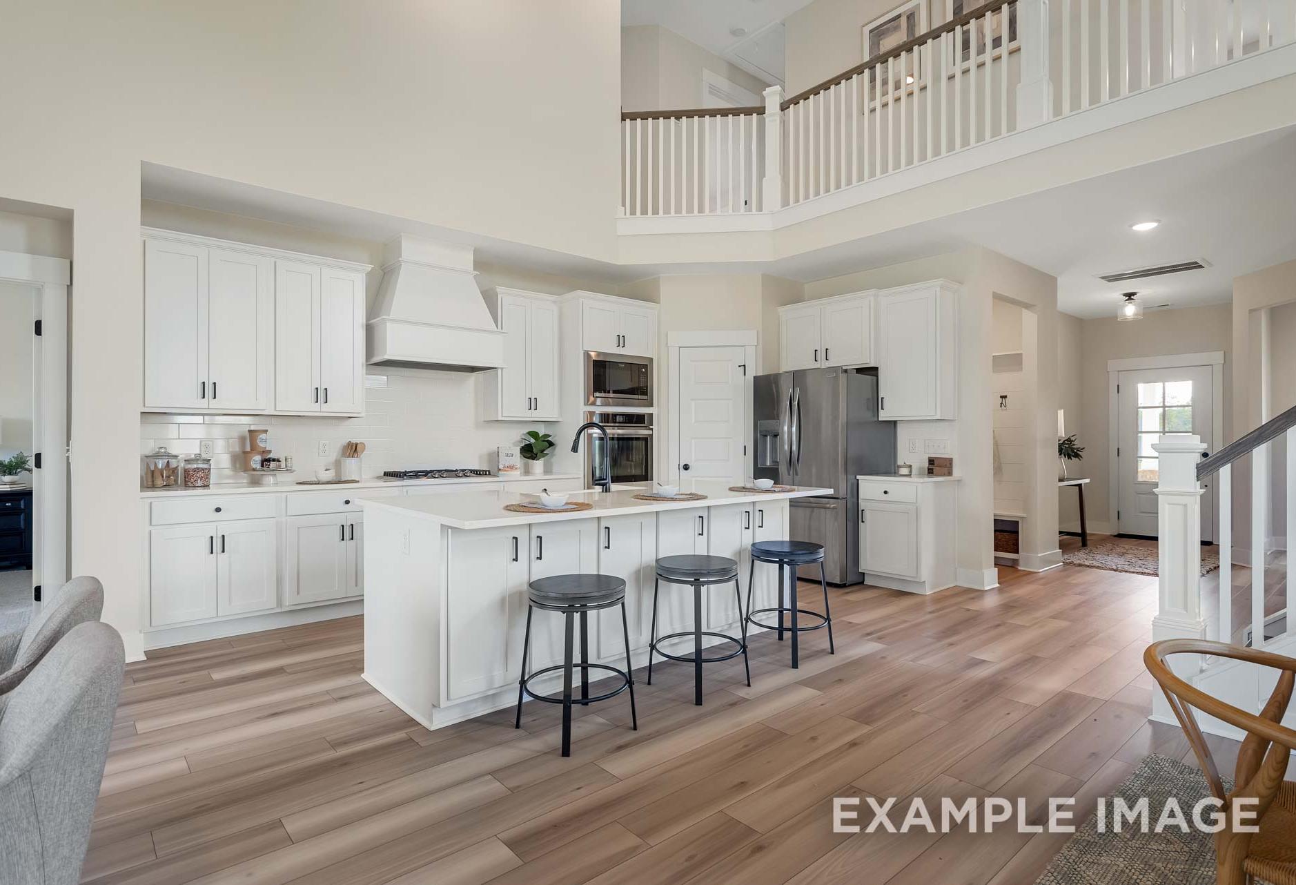 Open-concept kitchen with white cabinetry, large island, and vaulted ceiling in The Ridgeport by Davidson Homes, Mt. Juliet TN