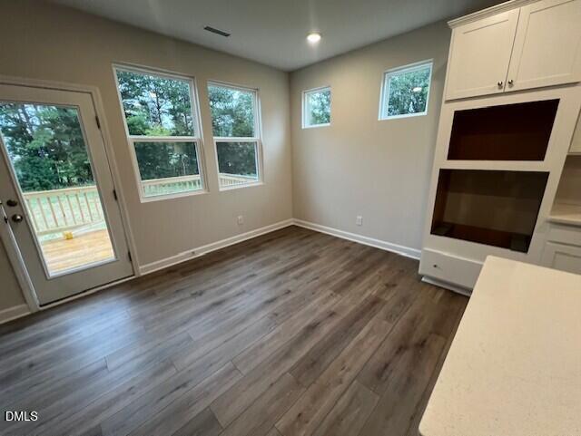 Bright dining area with luxury vinyl plank flooring, white cabinetry, and backyard views in Davidson Homes The Willow D, Lillington NC