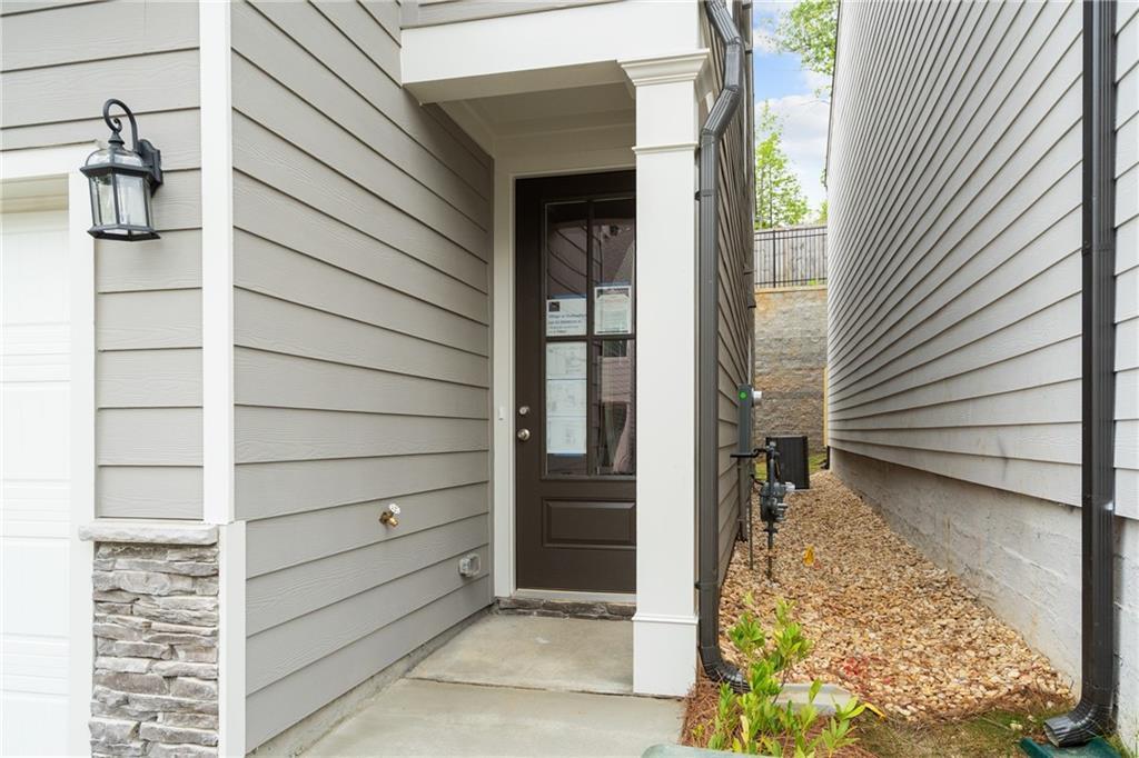 Modern two-story home exterior with gray siding, two-car garage, and brown glass front door in Kennesaw, Georgia