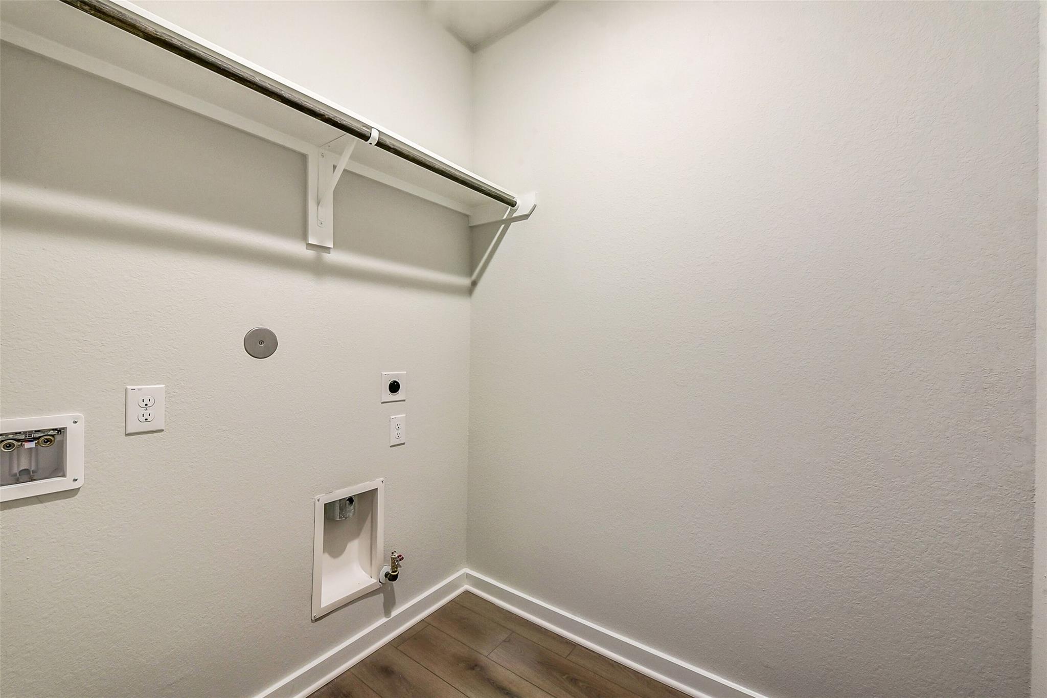 Bright laundry room with built-in shelving, hanging rod, washer/dryer hookups in Davidson Homes The Comal G, Dayton, Texas