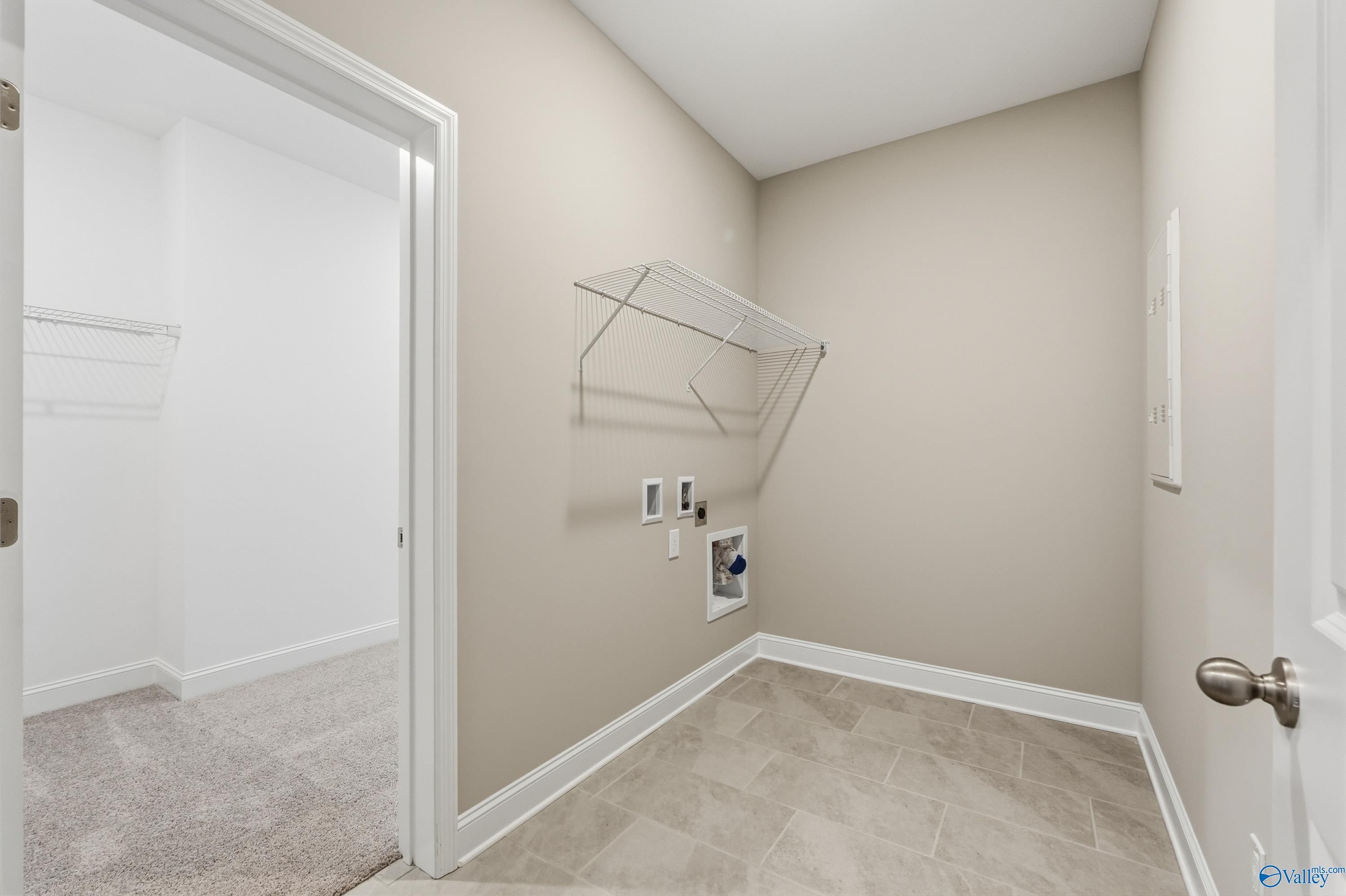 Spacious laundry room with open shelves, hanging rod and washer-dryer hookups in Davidson Homes The Rockford, Creekside, Harvest, Alabama